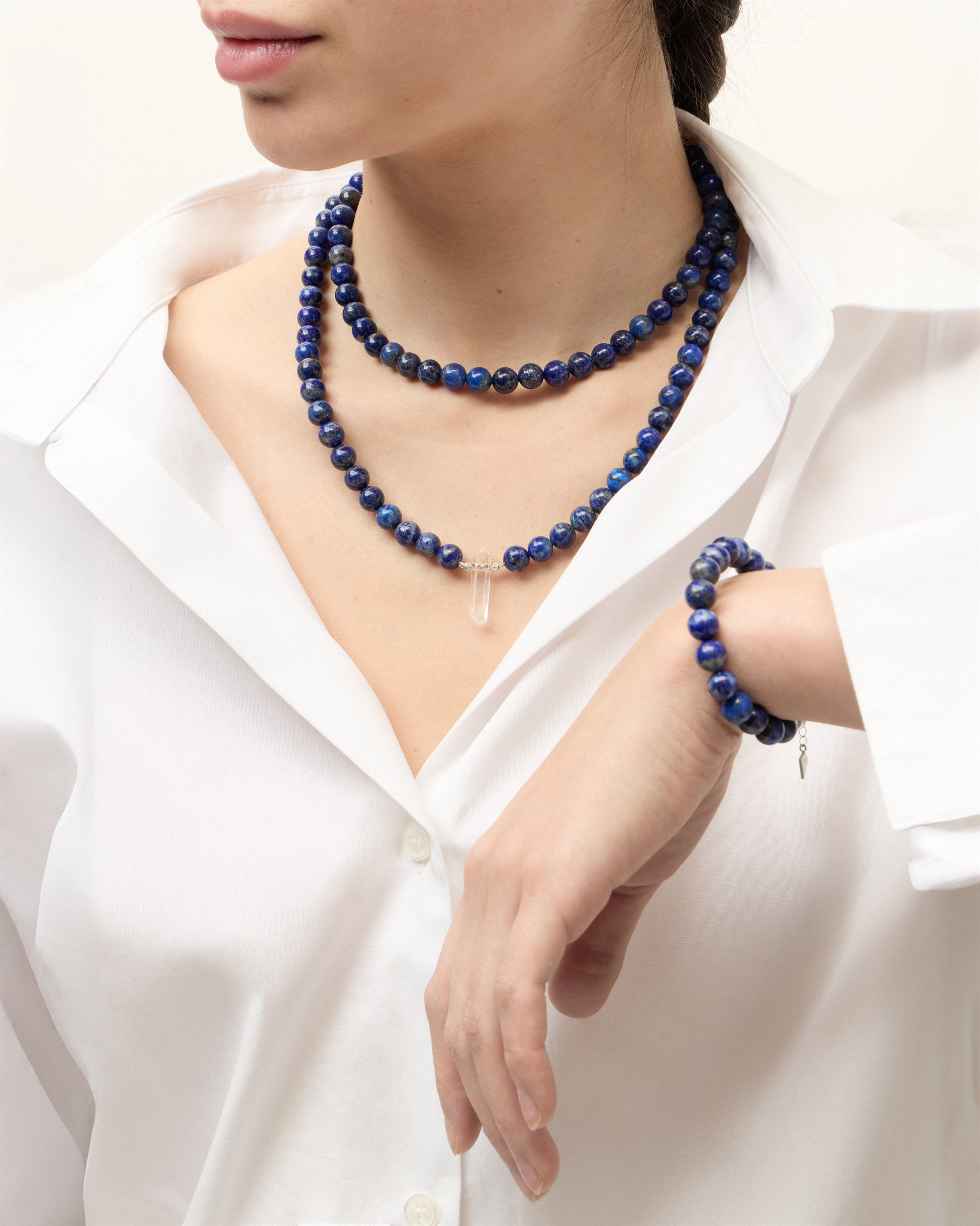 ENCARA / ETERNA NOCTA Lapis Lazuli necklaces and bracelet with polished silver spiral bead, extension chain and clasp, arrowhead-shaped fantasy signature, and 8 mm faceted lazurite bead strand and raw polished quartz point pendant.