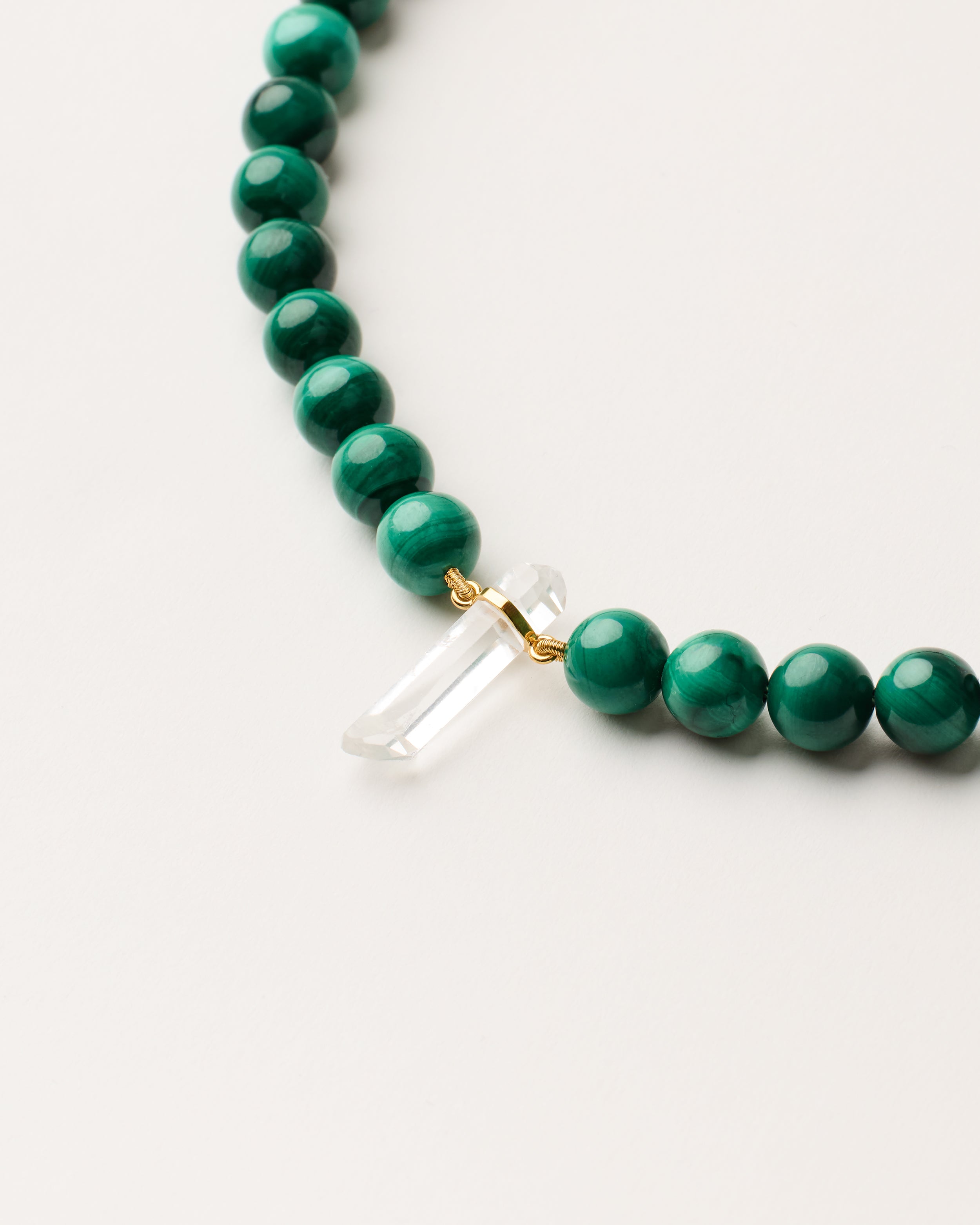 ENCARA VERDAN Malachite necklace with raw polished quartz point pendant, gold-plated silver 8 cm extension chain and clasp, arrowhead-shaped fantasy signature, and 8 mm faceted malachite bead strand.