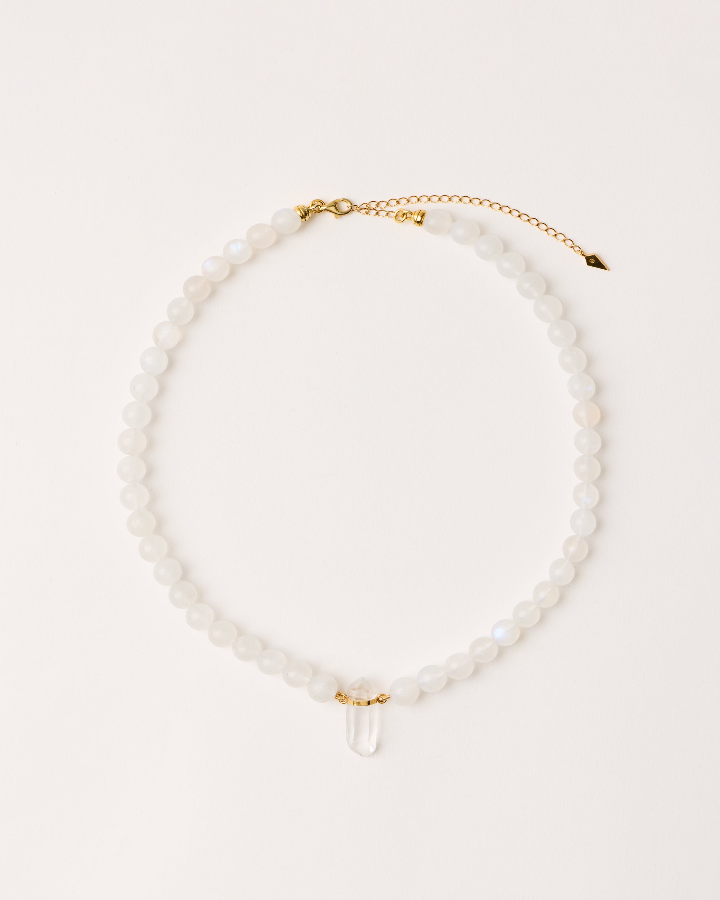 ENCARA LUNOR Moonstone necklace with raw polished quartz point pendant, gold-plated silver 8 cm extension chain and clasp, arrowhead-shaped fantasy signature, and 8 mm faceted moonstone bead strand.