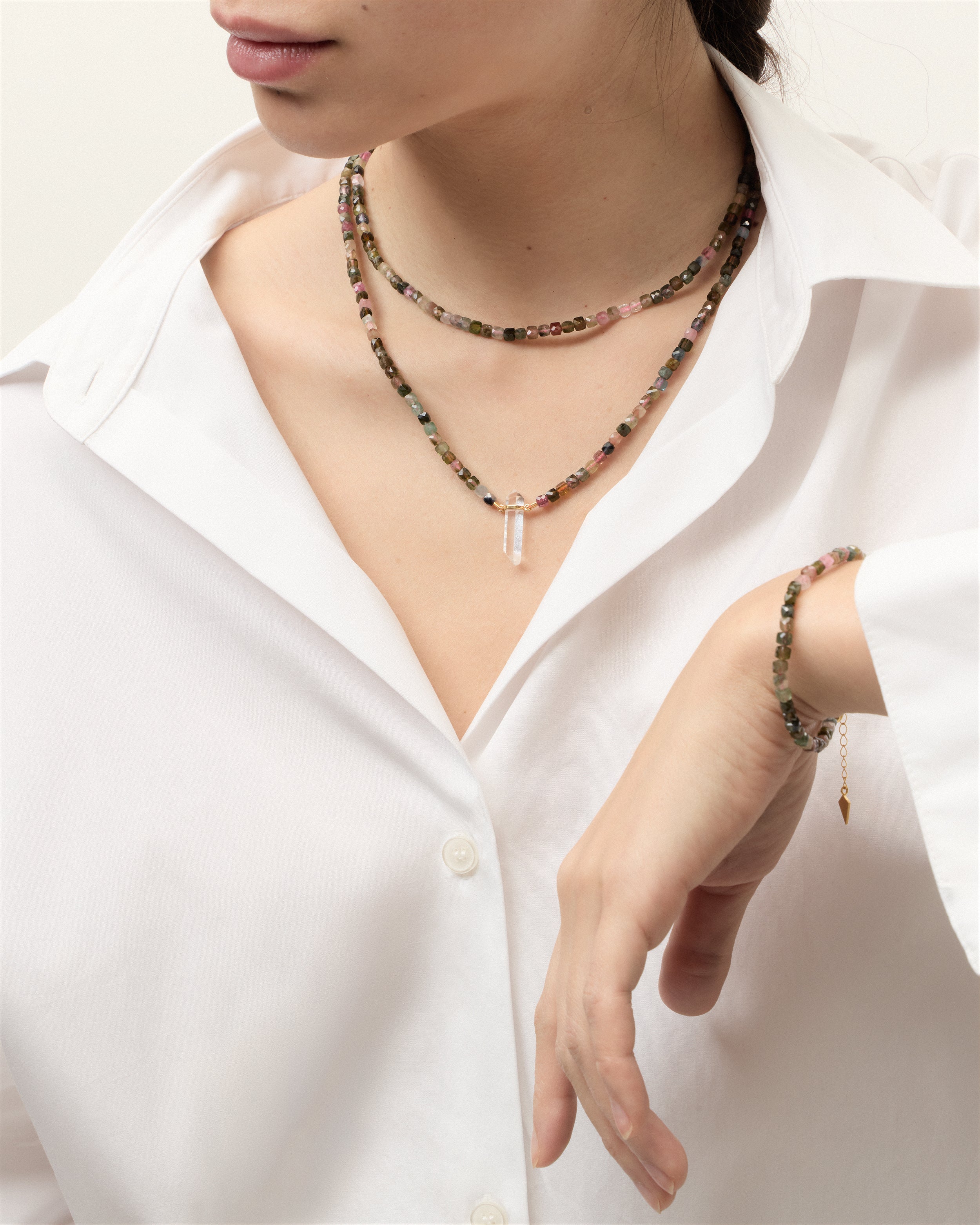 ENCARA / ETERNA AURIL Tourmaline necklaces and bracelet with polished gold-plated silver spiral bead, extension chain and clasp, arrowhead-shaped fantasy signature, and 4 mm faceted tourmaline bead strand and raw polished quartz point pendant.
