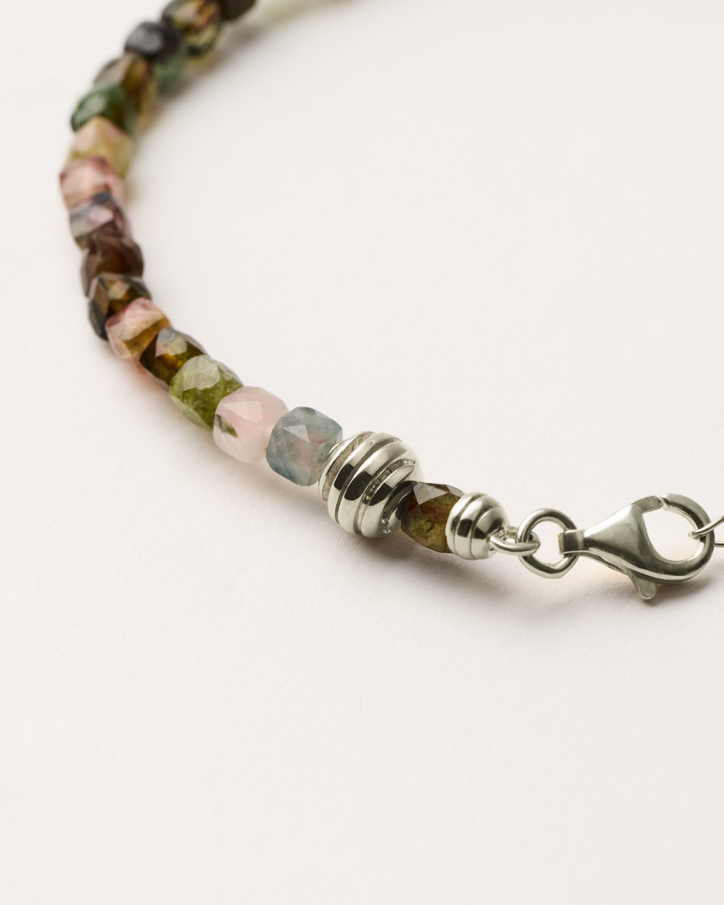 ETERNA AURIL Tourmaline bracelet with polished silver spiral bead, 4 cm extension chain and clasp, arrowhead-shaped fantasy signature, and 4 mm faceted tourmaline bead strand.