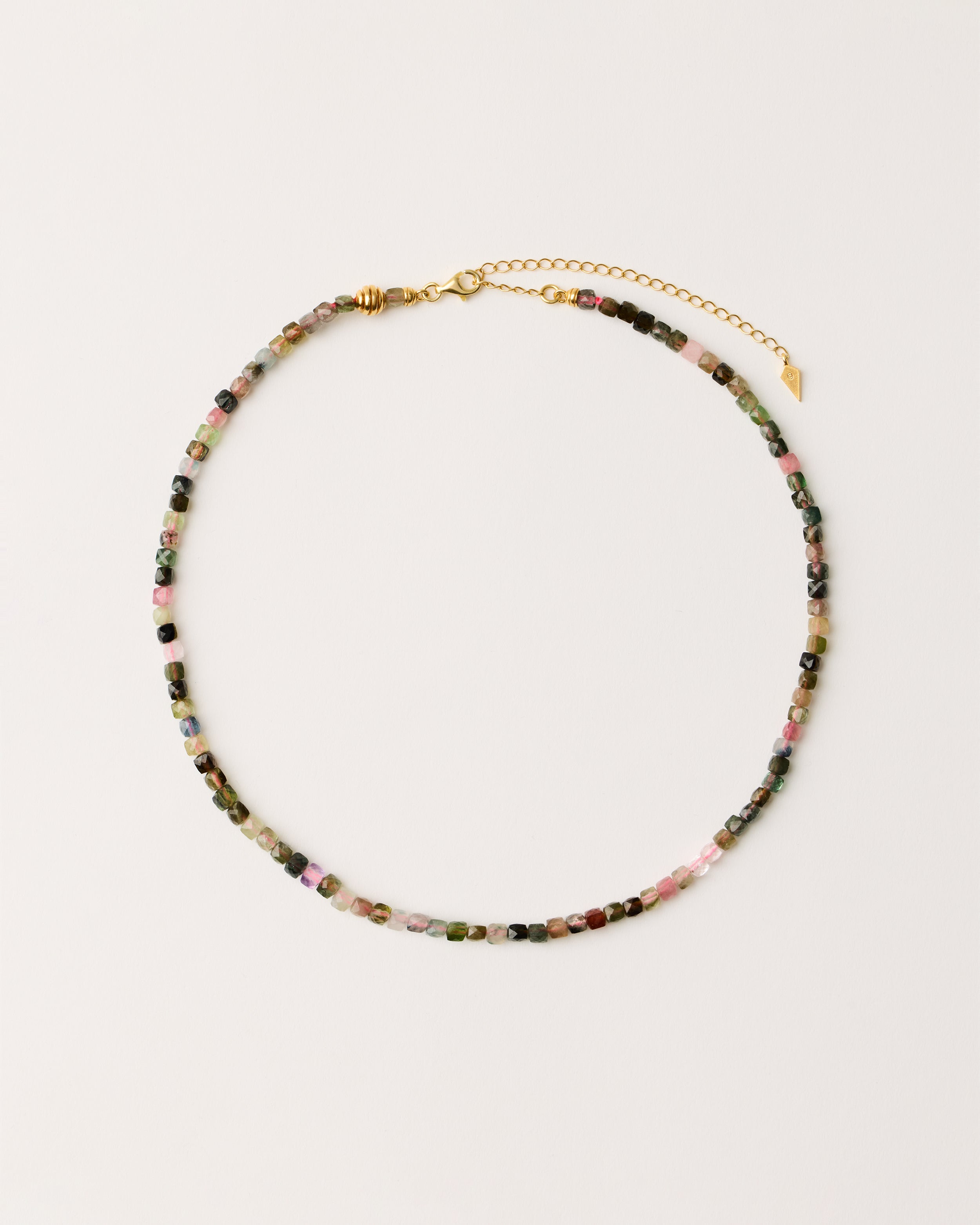 ETERNA AURIL Tourmaline necklace with polished gold-plated silver spiral bead, 8 cm extension chain and clasp, arrowhead-shaped fantasy signature, and 4 mm faceted tourmaline bead strand.