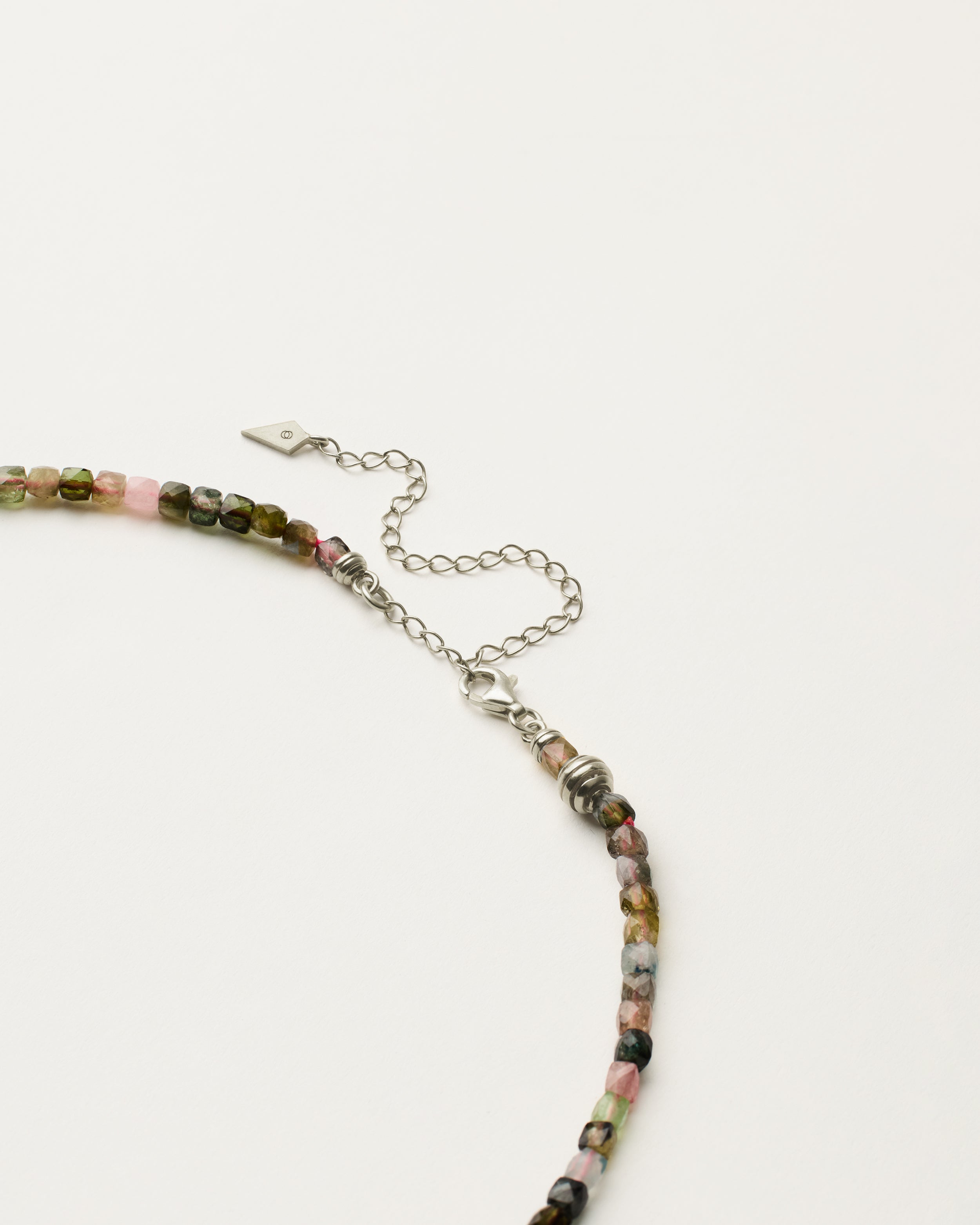 ETERNA AURIL Tourmaline necklace with polished silver spiral bead, 8 cm extension chain and clasp, arrowhead-shaped fantasy signature, and 4 mm faceted tourmaline bead strand.