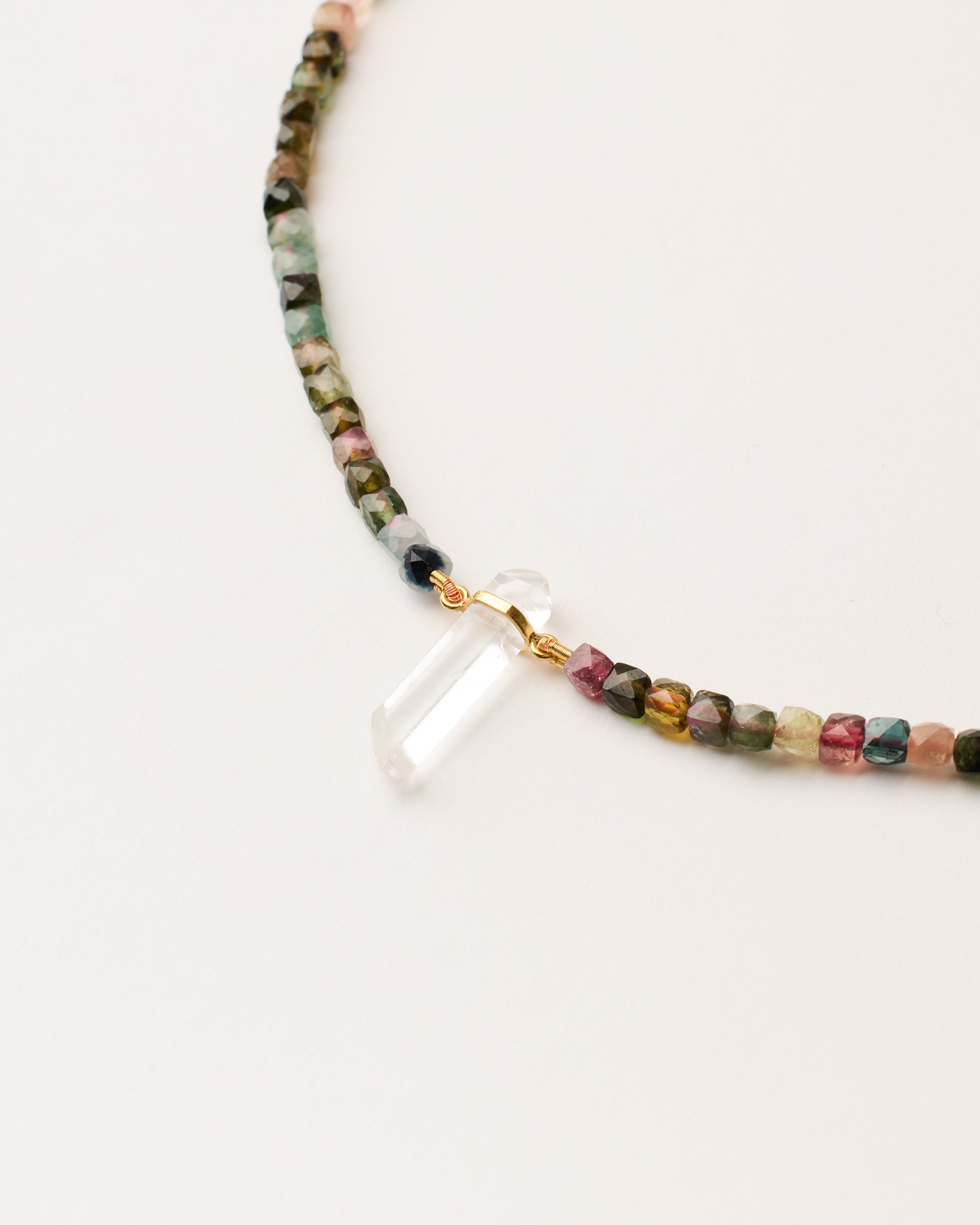ENCARA AURIL Tourmaline necklace with raw polished quartz point pendant, gold-plated silver 8 cm extension chain and clasp, arrowhead-shaped fantasy signature, and 4 mm faceted tourmaline bead strand.