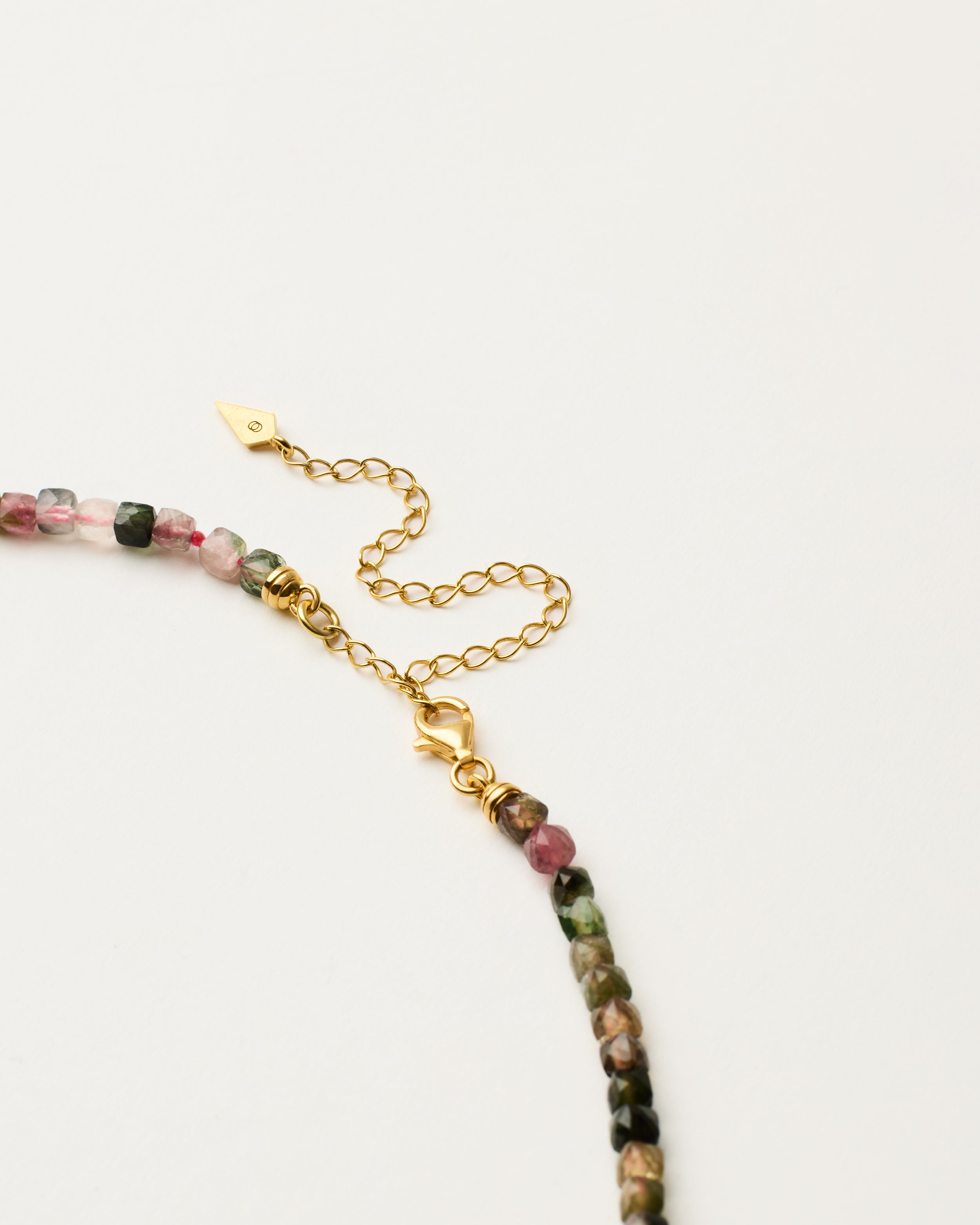 ENCARA AURIL Tourmaline necklace with raw polished quartz point pendant, gold-plated silver 8 cm extension chain and clasp, arrowhead-shaped fantasy signature, and 4 mm faceted tourmaline bead strand.