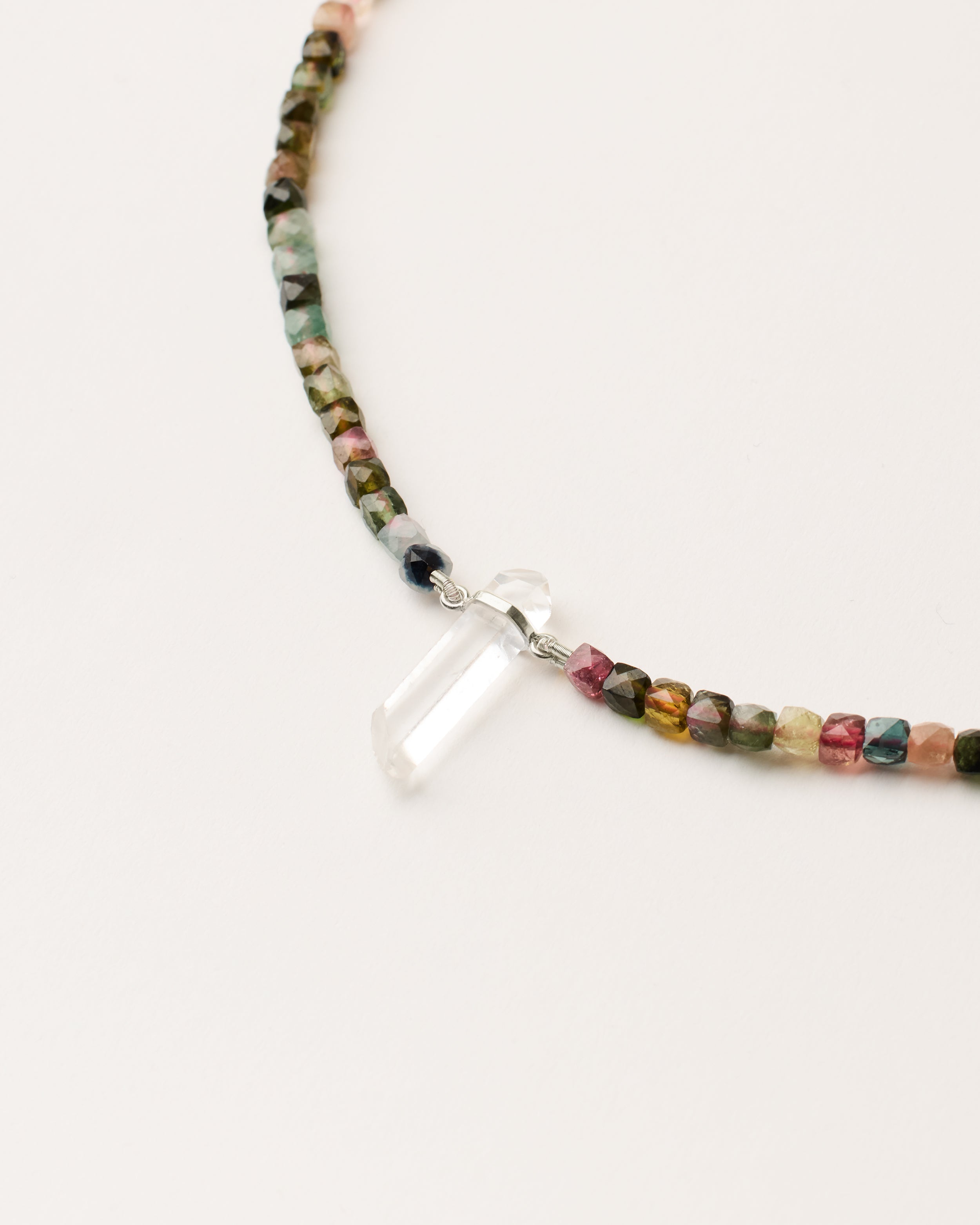 ENCARA AURIL Tourmaline necklace with raw polished quartz point pendant, silver 8 cm extension chain and clasp, arrowhead-shaped fantasy signature, and 4 mm faceted tourmaline bead strand.