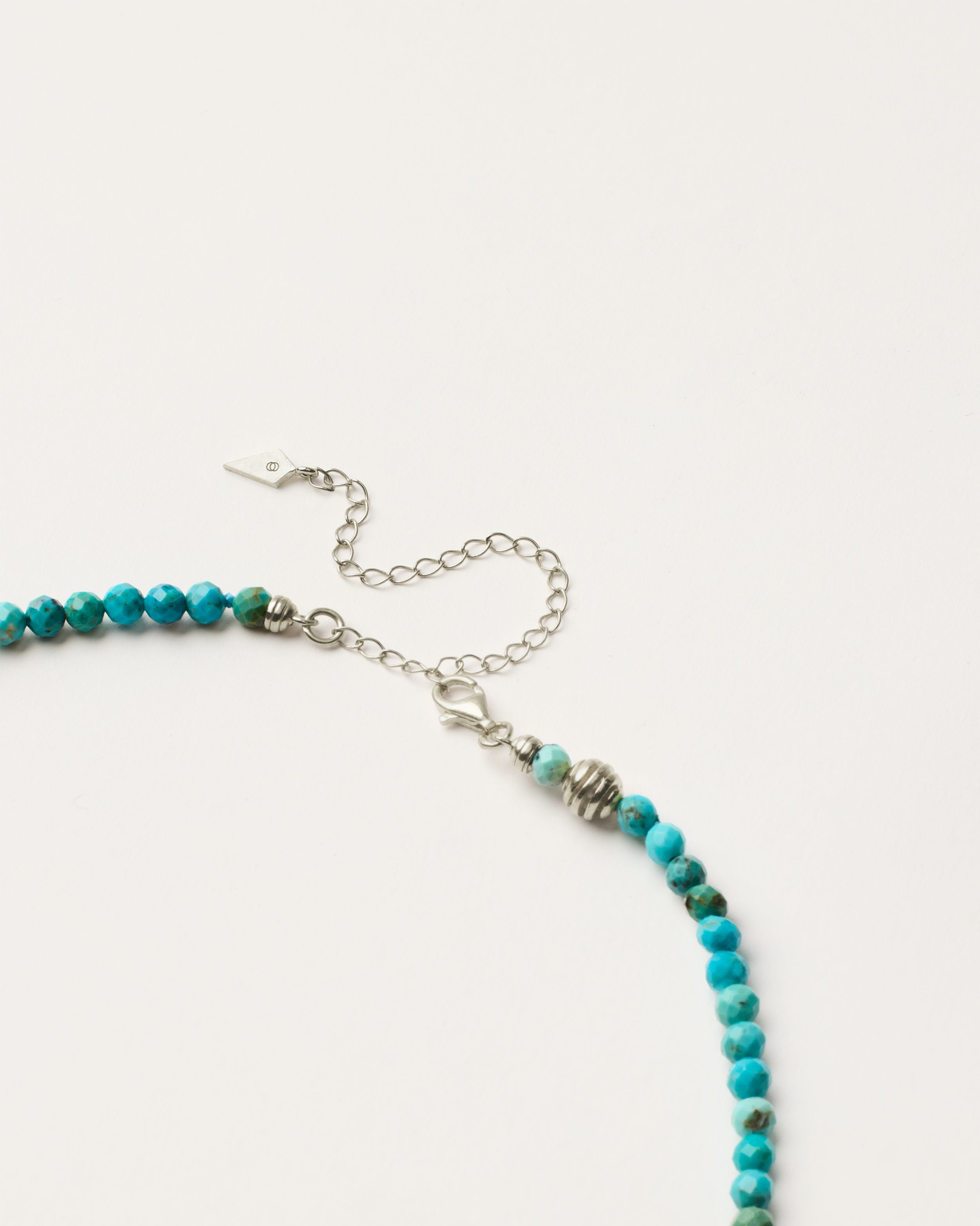 ETERNA AZURA Turquoise necklace with polished silver spiral bead, 8 cm extension chain and clasp, arrowhead-shaped fantasy signature, and 4 mm faceted turquoise bead strand.