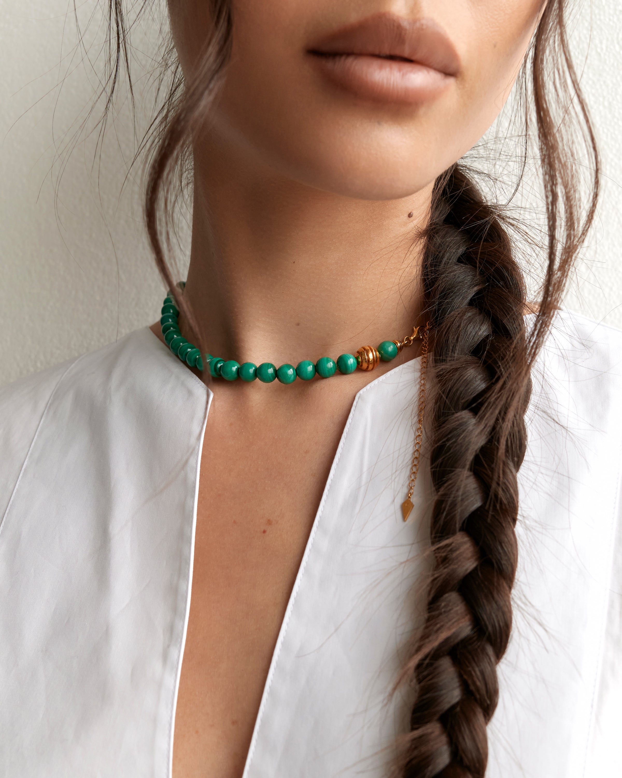 ENCARA VERDAN Malachite necklace with raw polished quartz point pendant, gold 8 cm extension chain and clasp, arrowhead-shaped fantasy signature, and 8 mm faceted malachite bead strand.