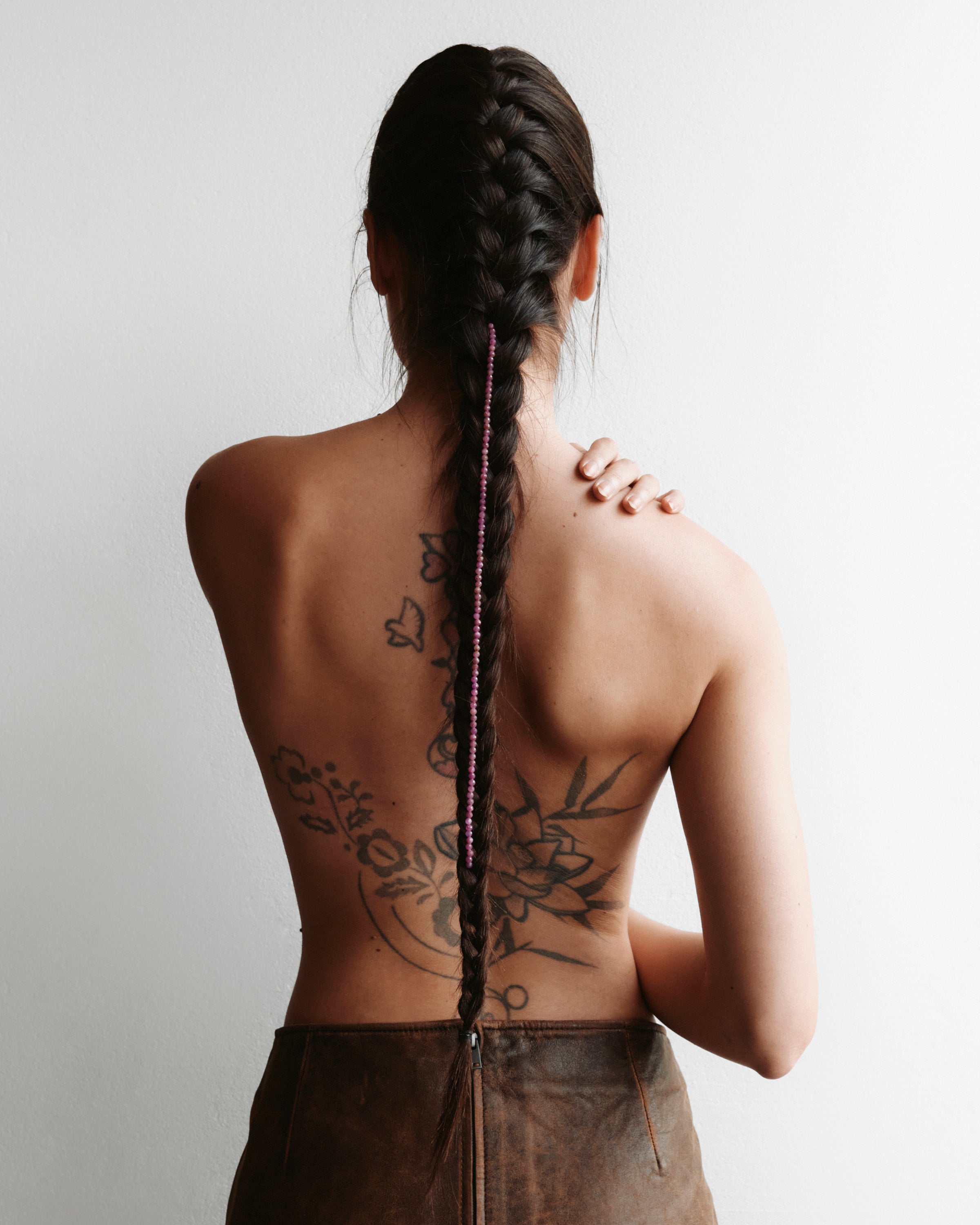 ETERNA CARMES Ruby necklace with polished gold spiral bead, 8 cm extension chain and clasp, arrowhead-shaped fantasy signature, and 4 mm faceted ruby bead strand.