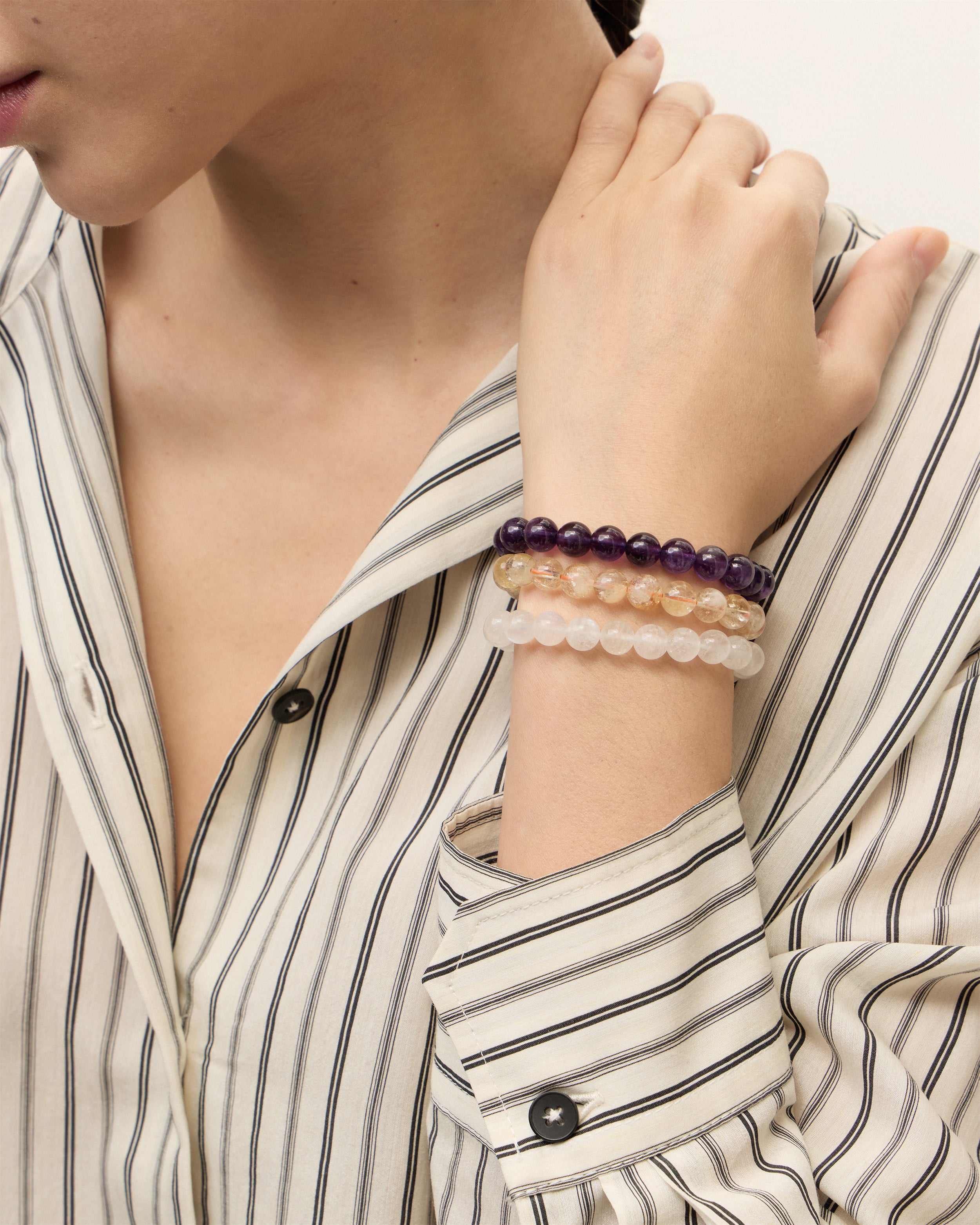 ETERNA VÉLA Amethyst / ETERNA SOLIS Citrine / ETERNA LUNOR Moonstone bracelet with polished gold spiral bead, 4 cm extension chain and clasp, arrowhead-shaped fantasy signature, and 8 mm faceted amethyst / citrine / moonstone bead strand.