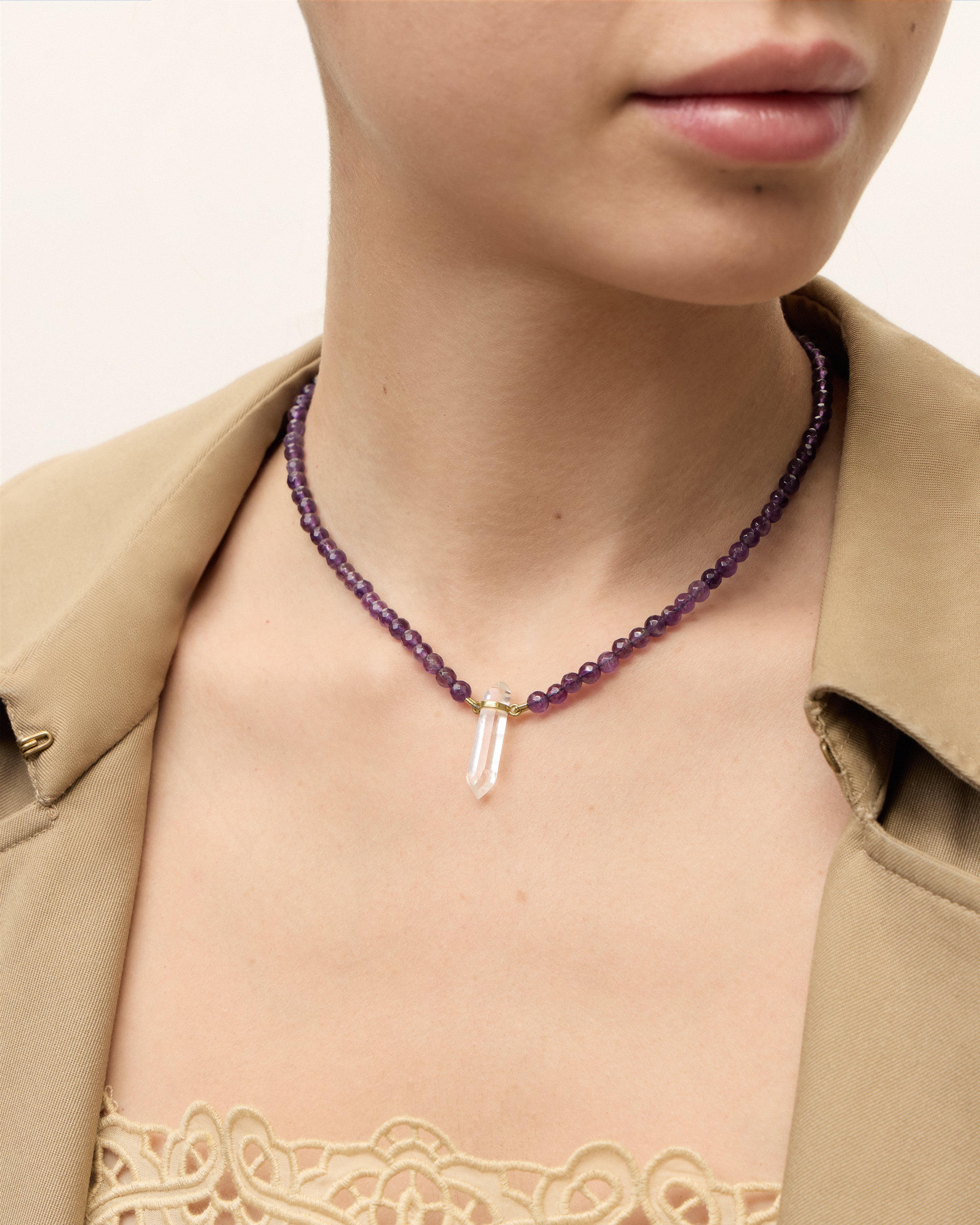 ENCARA VÉLA Amethyst necklace with raw polished quartz point pendant, gold 8 cm extension chain and clasp, arrowhead-shaped fantasy signature, and 4 mm faceted amethyst bead strand.