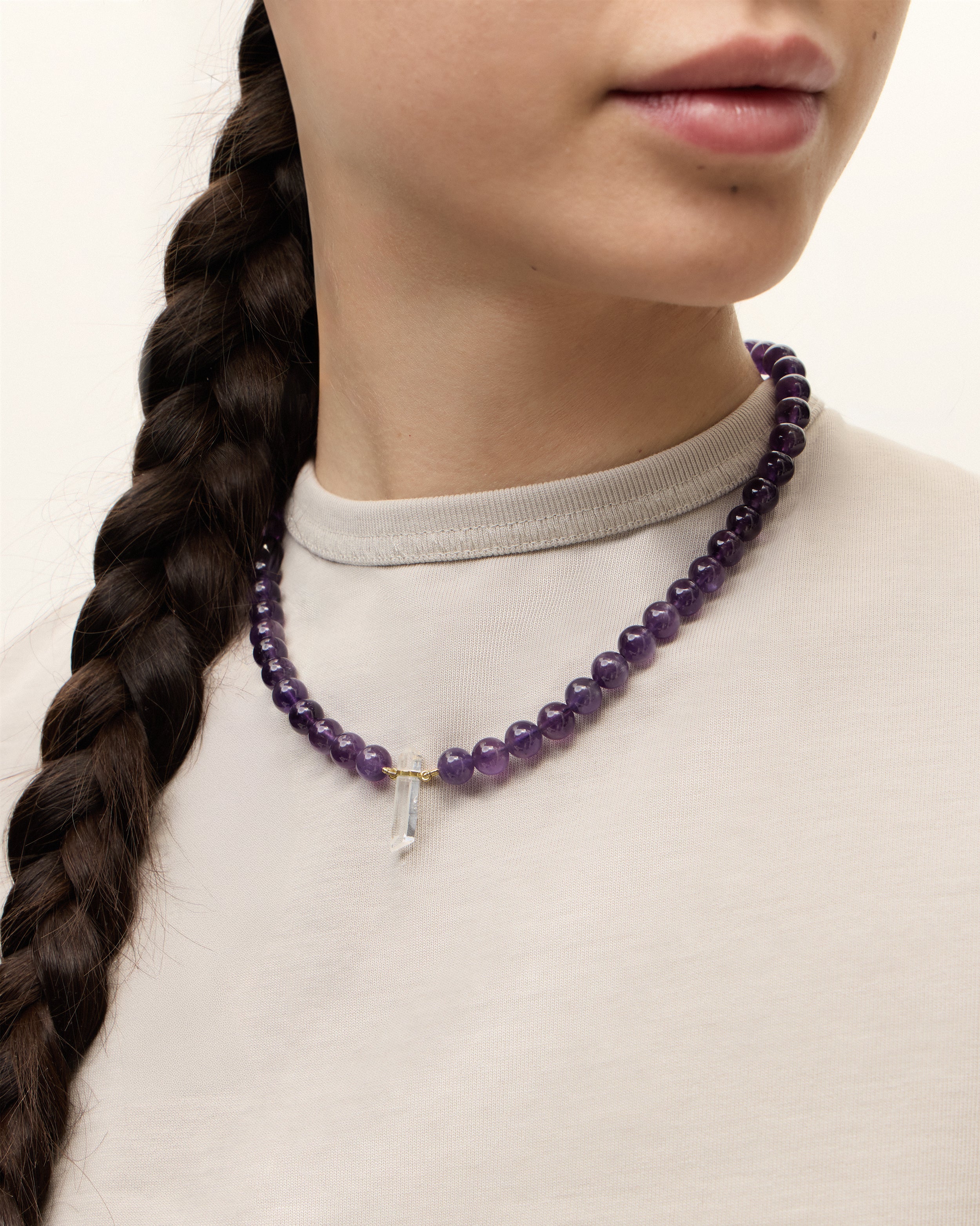 ENCARA VÉLA Amethyst necklace with raw polished quartz point pendant, gold 8 cm extension chain and clasp, arrowhead-shaped fantasy signature, and 8 mm faceted amethyst bead strand.