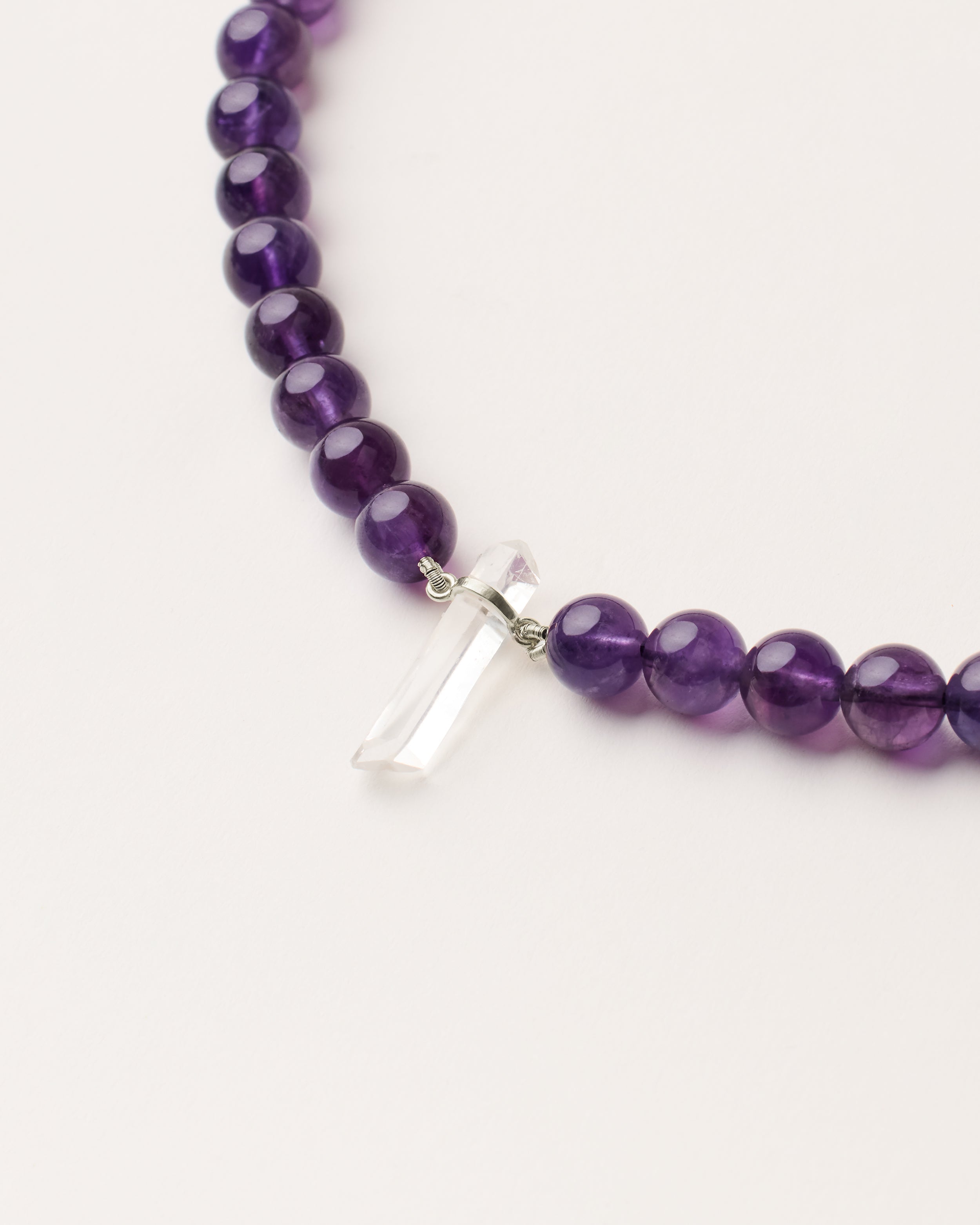 ENCARA VÉLA Amethyst necklace with raw polished quartz point pendant, silver 8 cm extension chain and clasp, arrowhead-shaped fantasy signature, and 8 mm faceted amethyst bead strand.