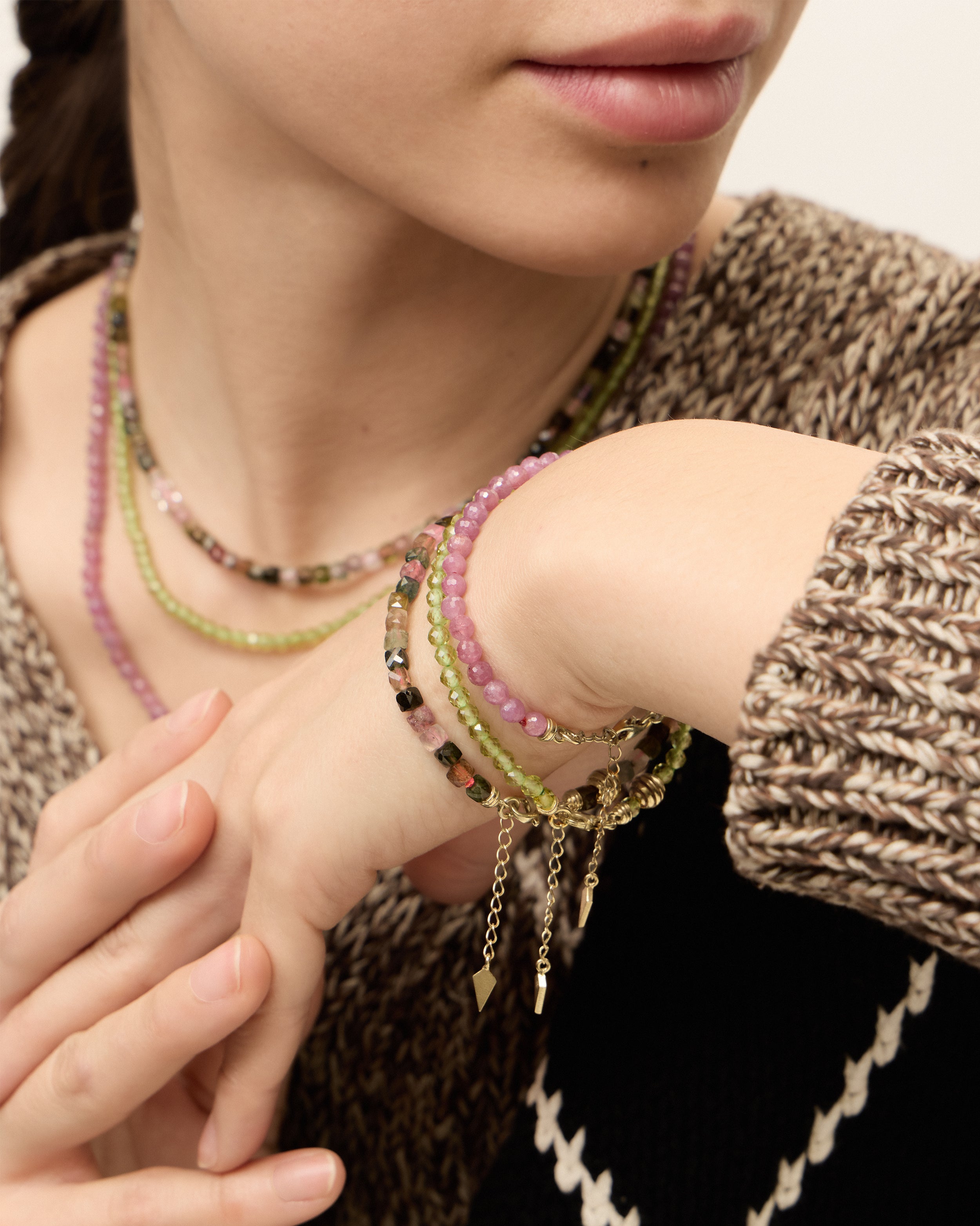 ETERNA OLMAR Peridot / ETERNA CARMES Ruby / ETERNA AURIL Tourmaline bracelet with polished gold spiral bead, 4 cm extension chain and clasp, arrowhead-shaped fantasy signature, and 4 mm faceted chrysolite / ruby / tourmaline bead strand.