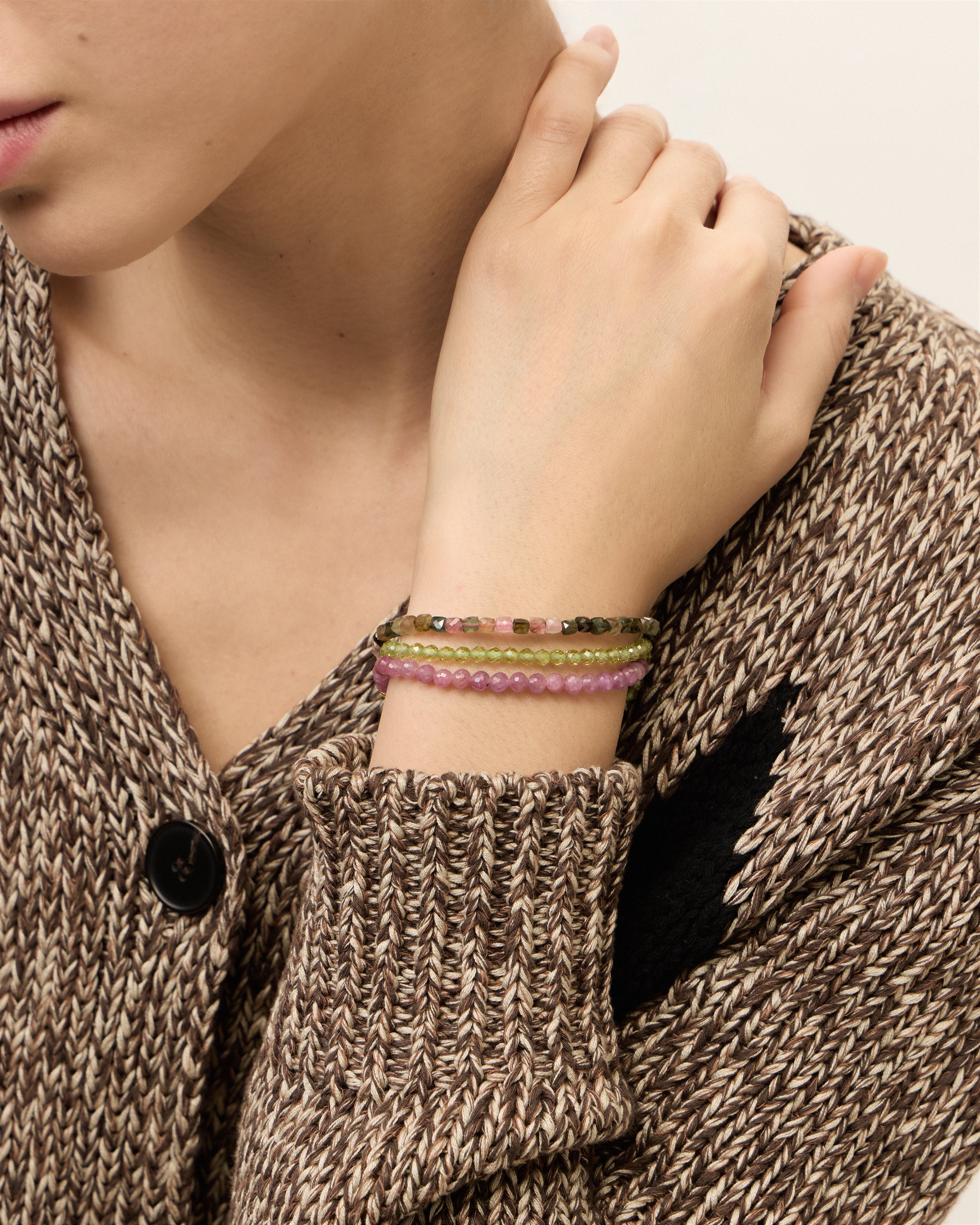 ETERNA OLMAR Peridot / ETERNA CARMES Ruby / ETERNA AURIL Tourmaline bracelet with polished gold spiral bead, 4 cm extension chain and clasp, arrowhead-shaped fantasy signature, and 4 mm faceted chrysolite / ruby / tourmaline bead strand.