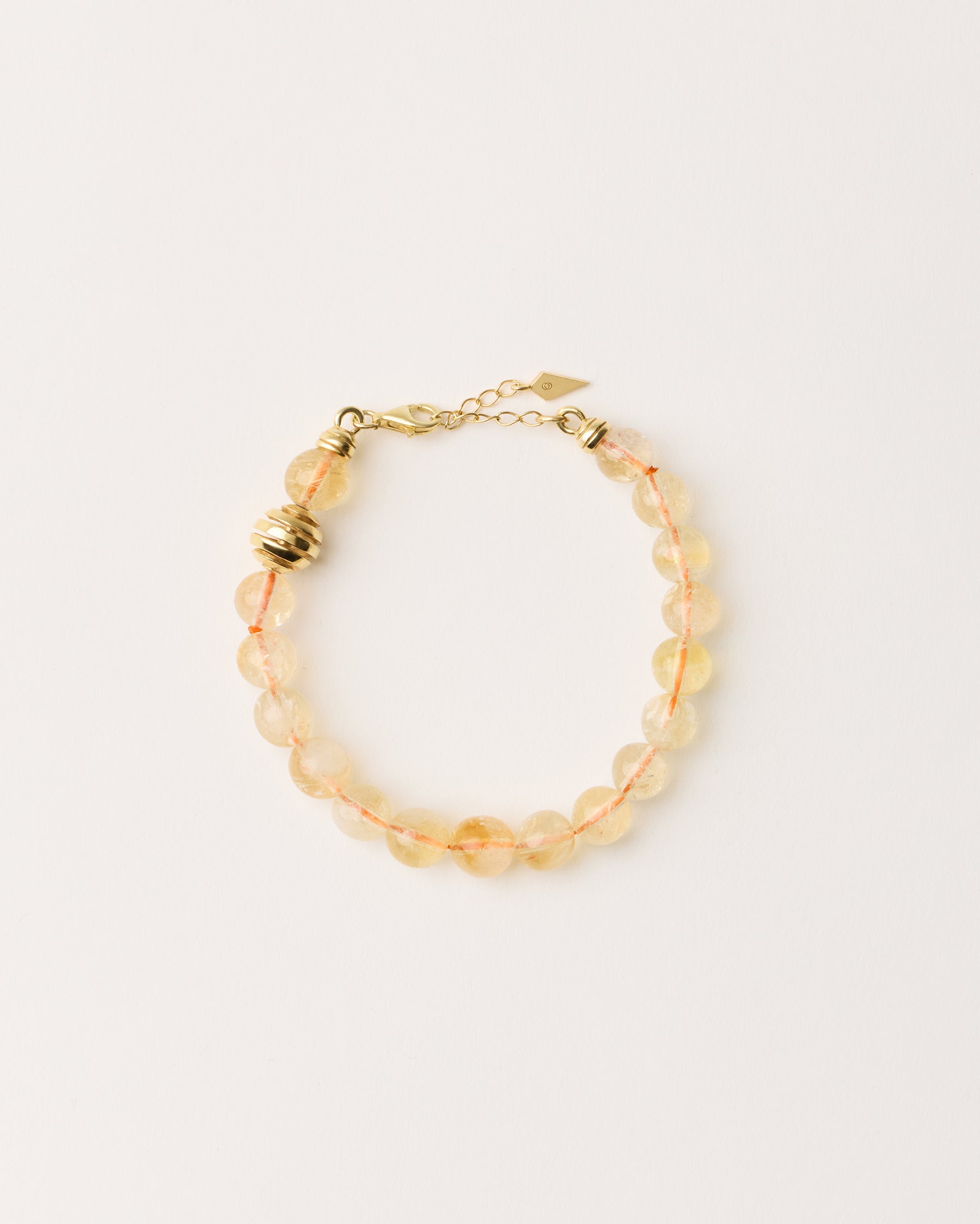 ETERNA SOLIS Citrine bracelet with polished gold spiral bead, 4 cm extension chain and clasp, arrowhead-shaped fantasy signature, and 8 mm faceted citrine bead strand.