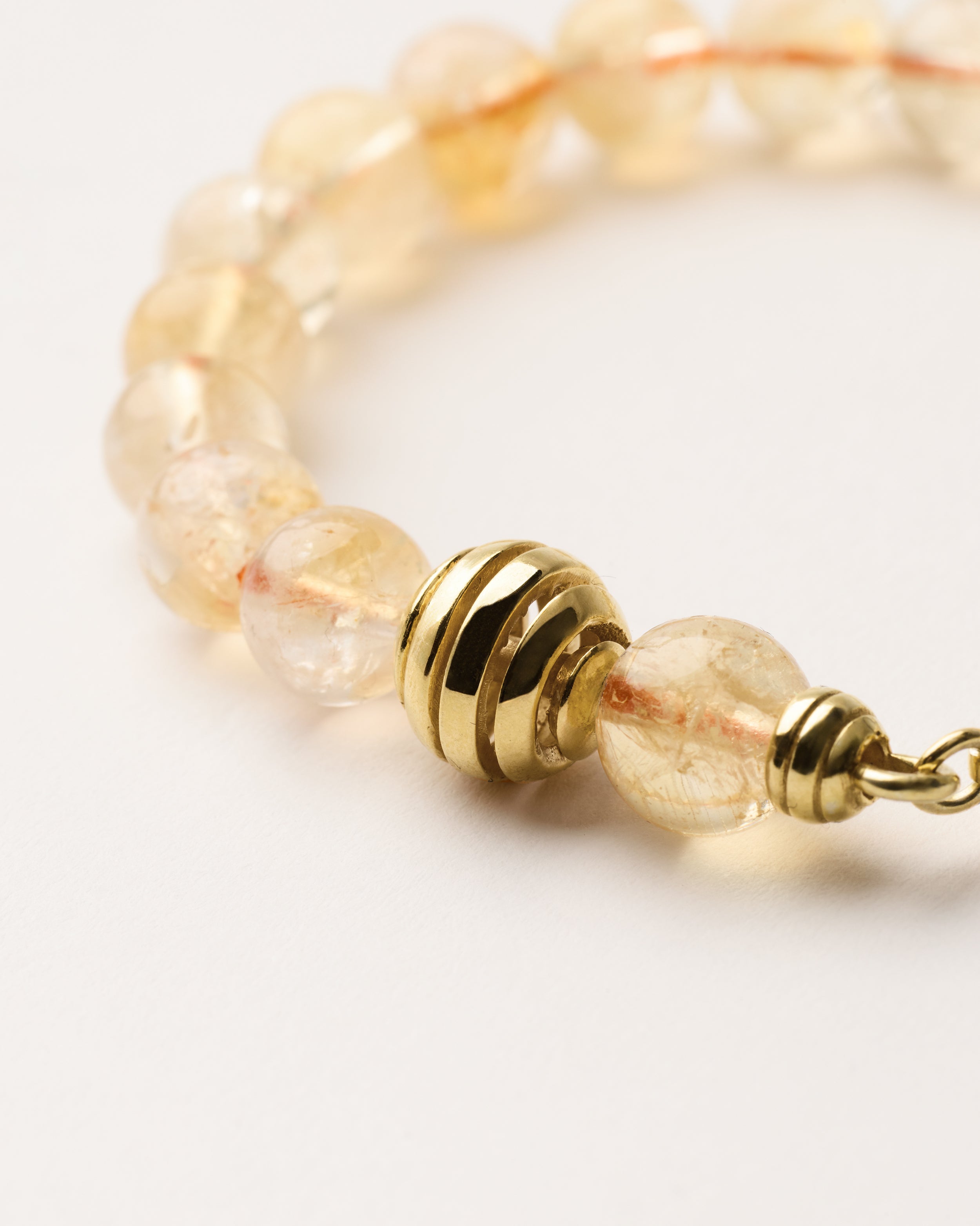 ETERNA SOLIS Citrine bracelet with polished gold spiral bead, 4 cm extension chain and clasp, arrowhead-shaped fantasy signature, and 8 mm faceted citrine bead strand.