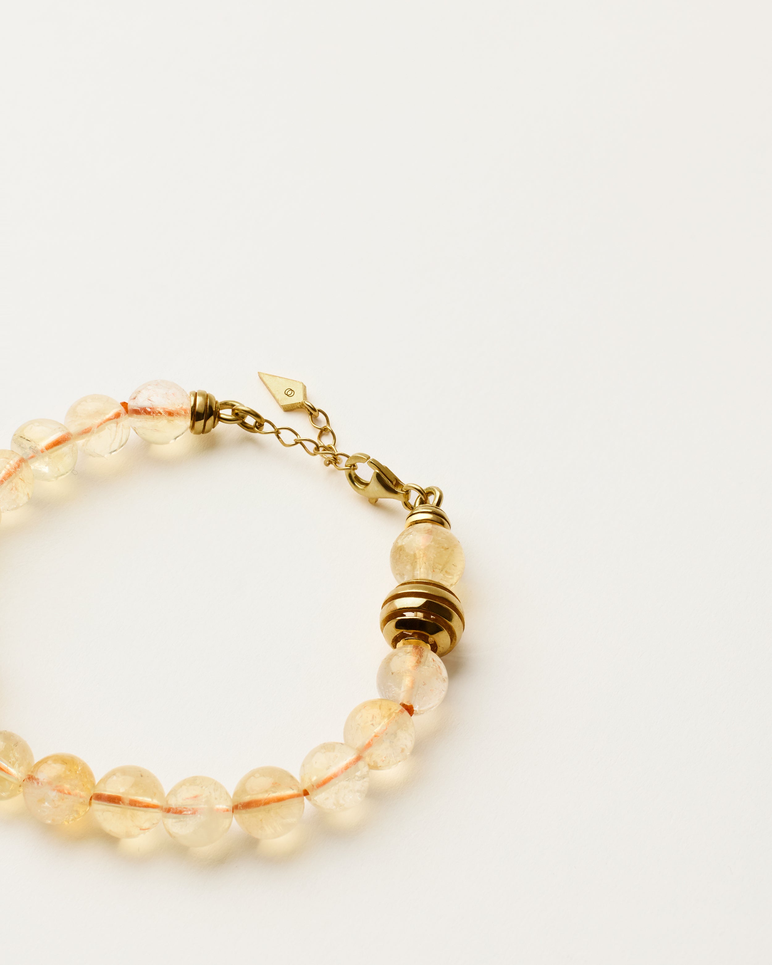ETERNA SOLIS Citrine bracelet with polished gold spiral bead, 4 cm extension chain and clasp, arrowhead-shaped fantasy signature, and 8 mm faceted citrine bead strand.
