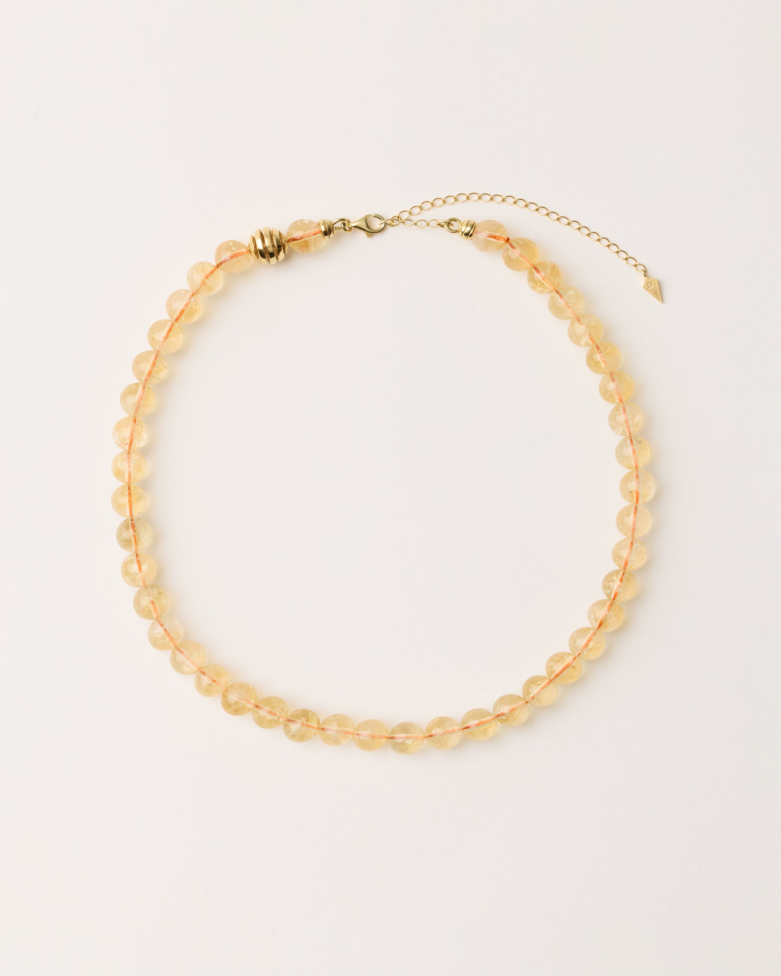 ETERNA SOLIS Citrine necklace with polished gold spiral bead, 8 cm extension chain and clasp, arrowhead-shaped fantasy signature, and 8 mm faceted citrine bead strand.