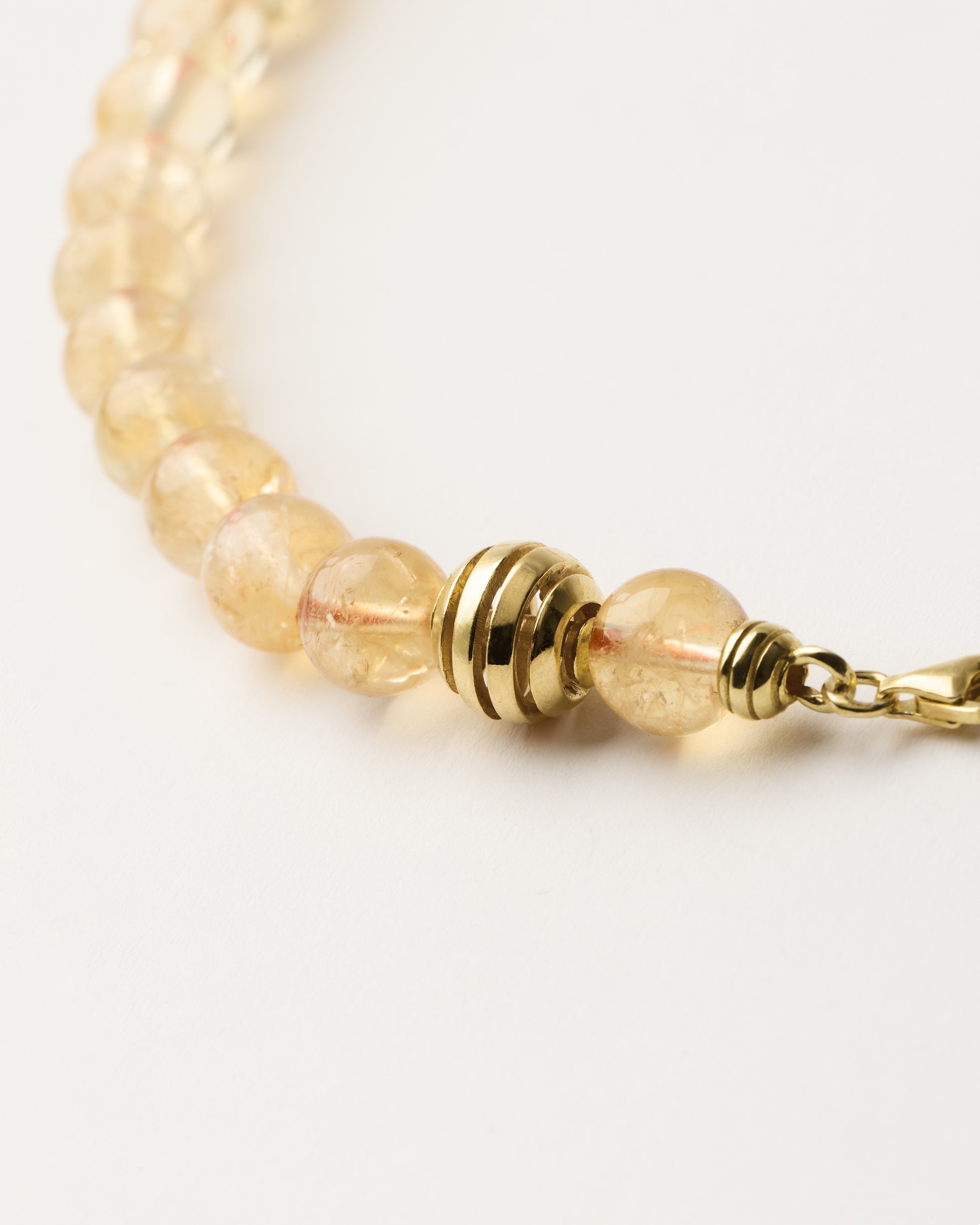 ETERNA SOLIS Citrine necklace with polished gold spiral bead, 8 cm extension chain and clasp, arrowhead-shaped fantasy signature, and 8 mm faceted citrine bead strand.
