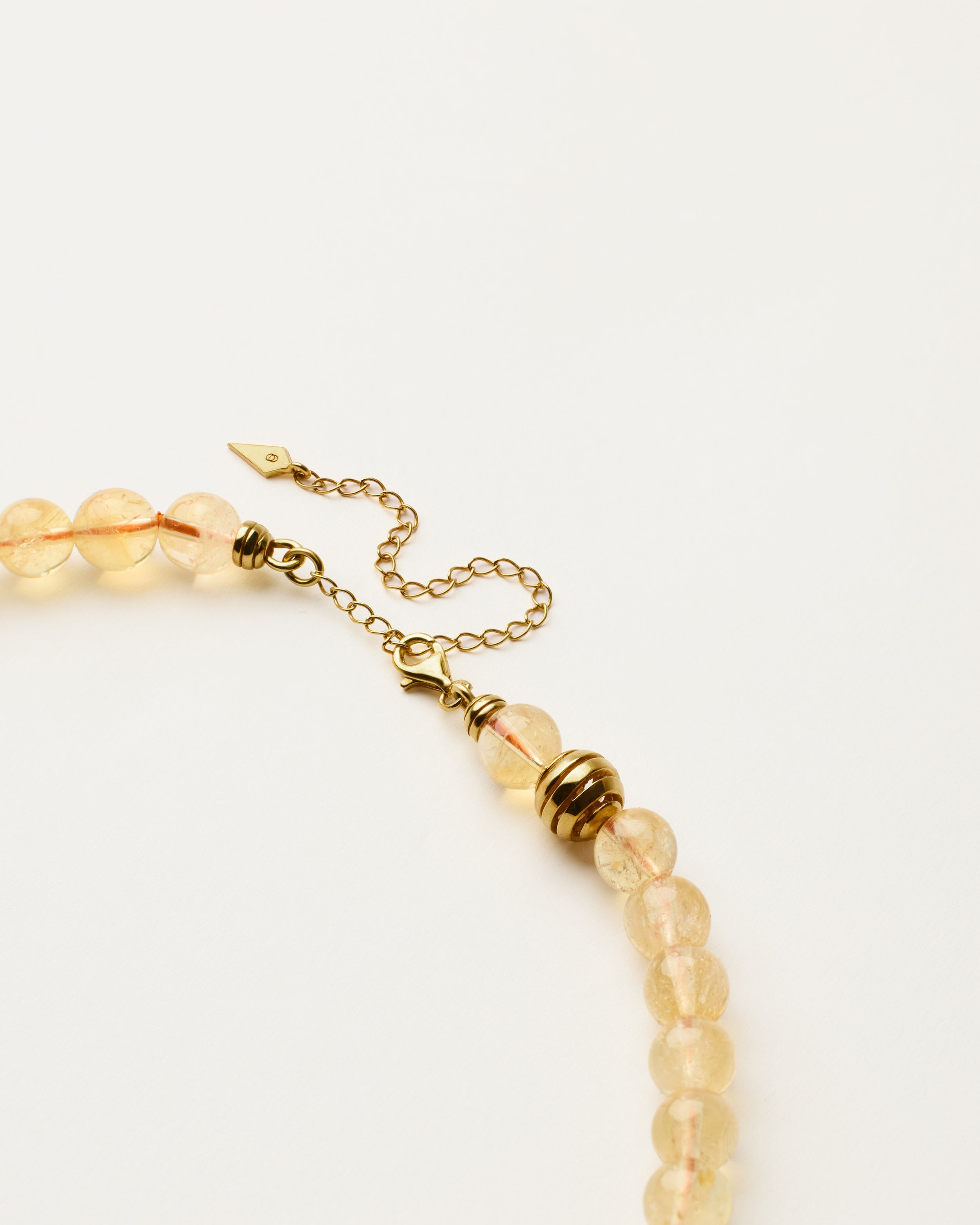 ETERNA SOLIS Citrine necklace with polished gold spiral bead, 8 cm extension chain and clasp, arrowhead-shaped fantasy signature, and 8 mm faceted citrine bead strand.