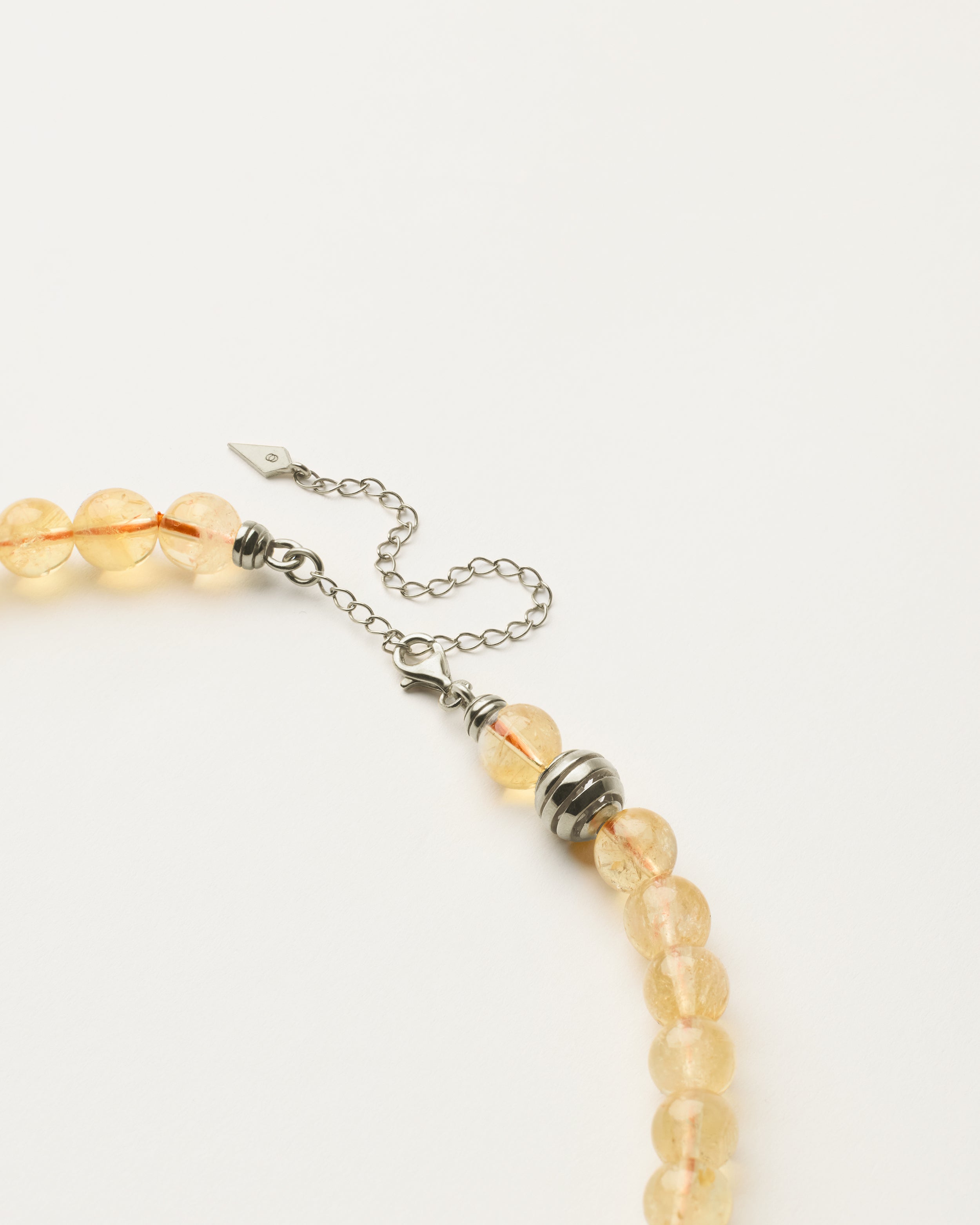ETERNA SOLIS Citrine necklace with polished silver spiral bead, 8 cm extension chain and clasp, arrowhead-shaped fantasy signature, and 8 mm faceted citrine bead strand.