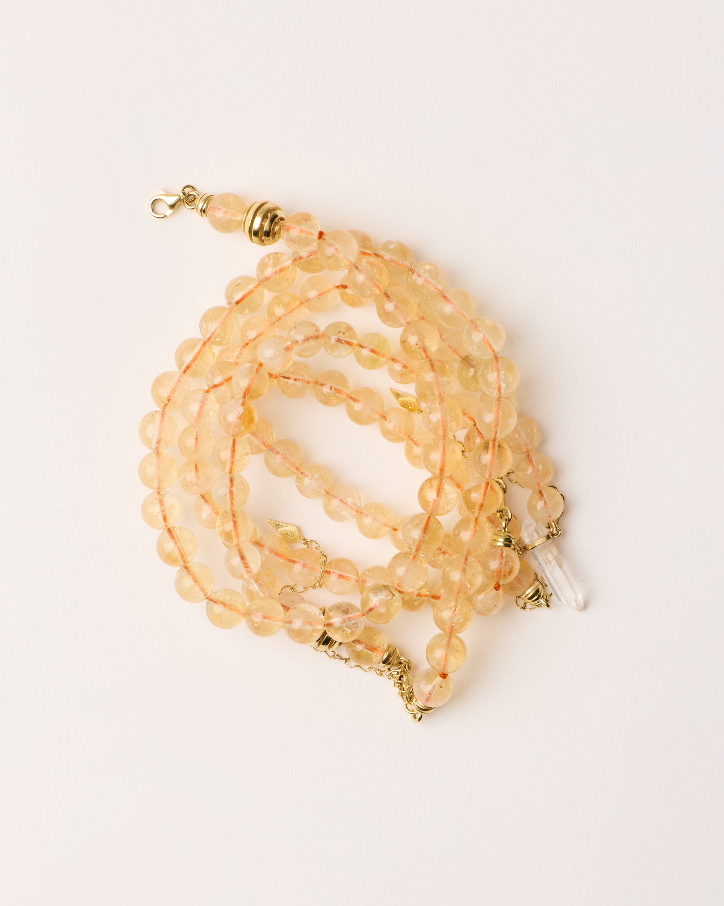 ENCARA / ETERNA SOLIS Citrine necklaces and bracelet with polished gold spiral bead, extension chain and clasp, arrowhead-shaped fantasy signature, and 8 mm faceted citrine bead strand and raw polished quartz point pendant.