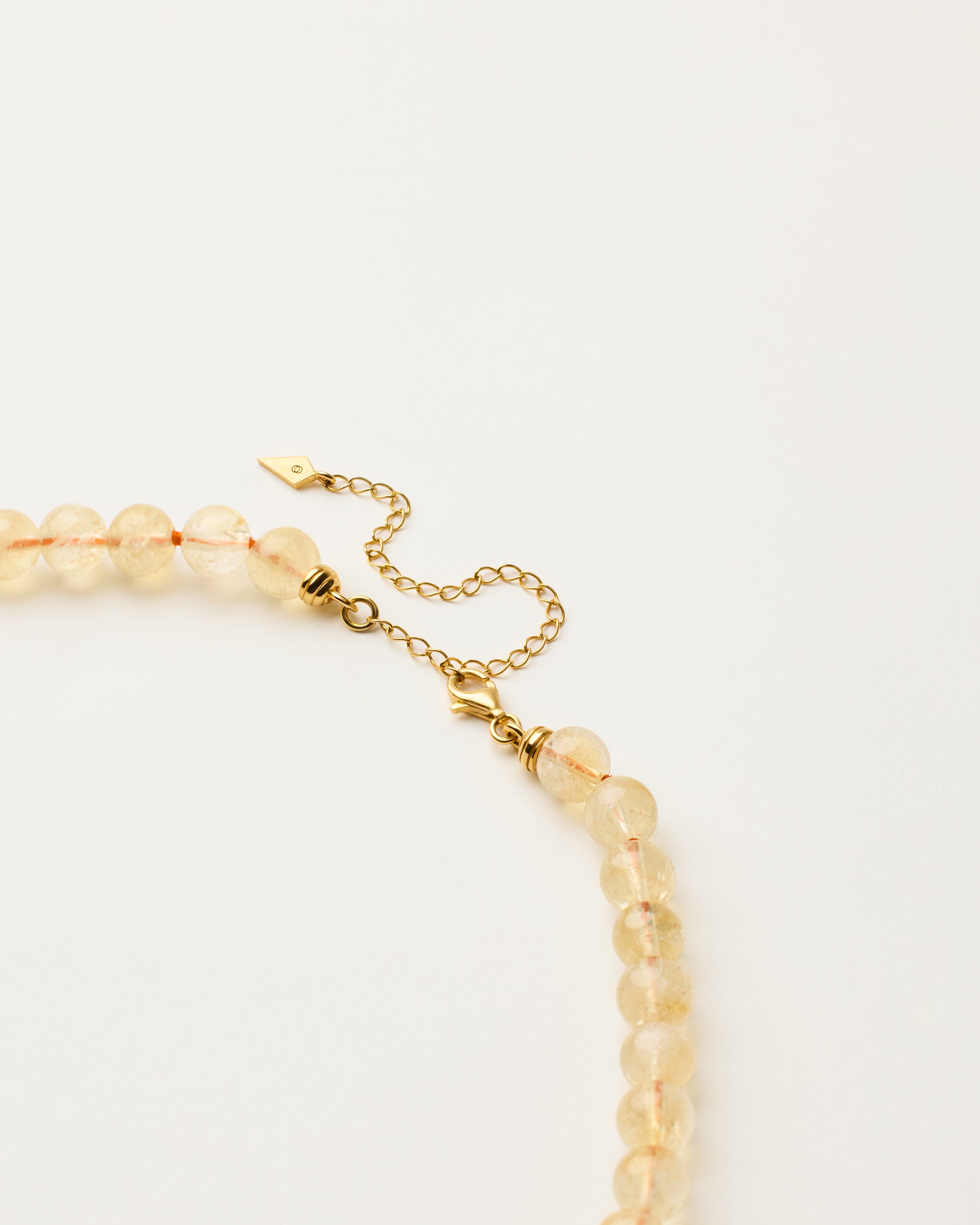 ENCARA SOLIS Citrine necklace with raw polished quartz point pendant, gold-plated silver 8 cm extension chain and clasp, arrowhead-shaped fantasy signature, and 8 mm faceted citrine bead strand.