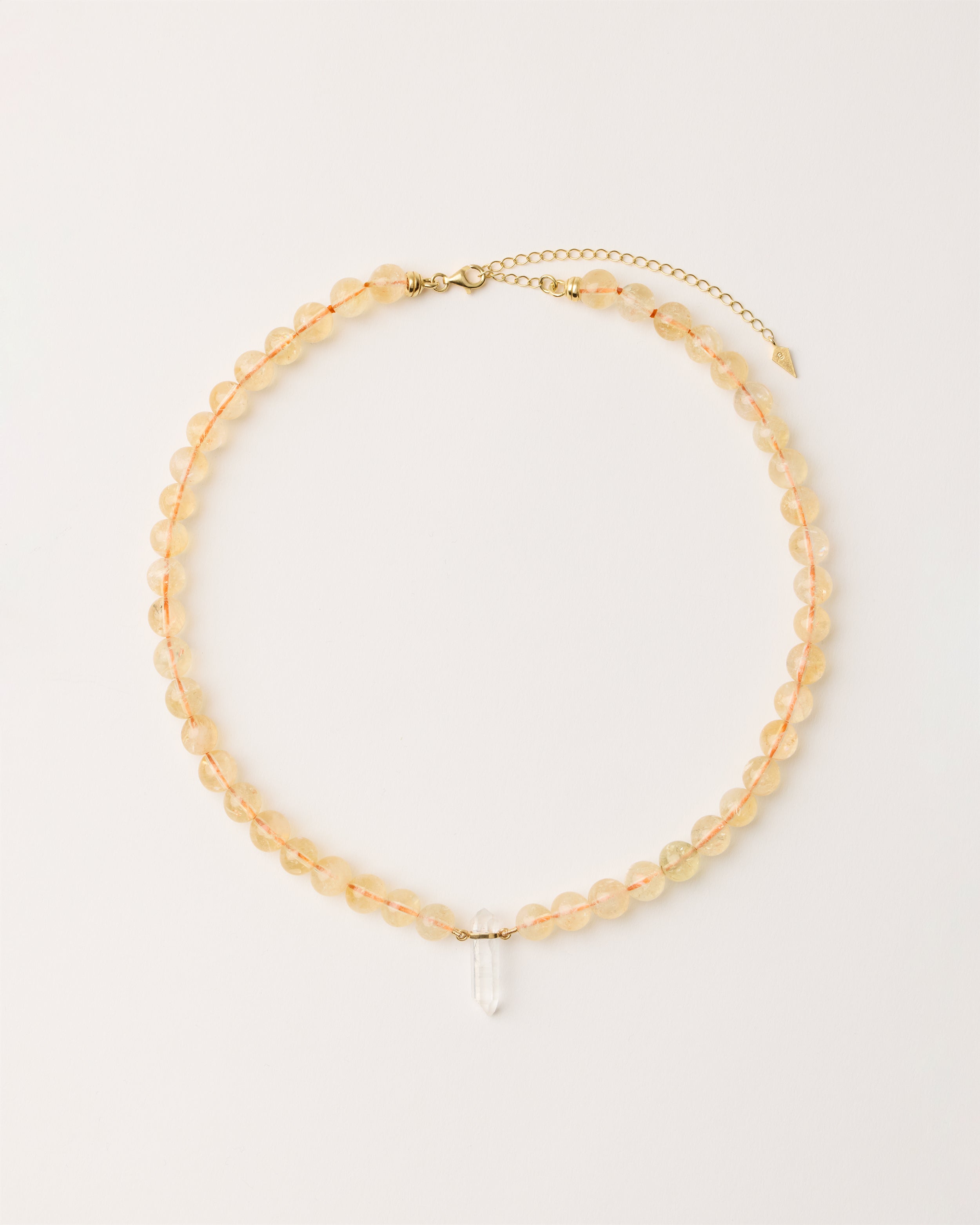 ENCARA SOLIS Citrine necklace with raw polished quartz point pendant, gold 8 cm extension chain and clasp, arrowhead-shaped fantasy signature, and 8 mm faceted citrine bead strand.