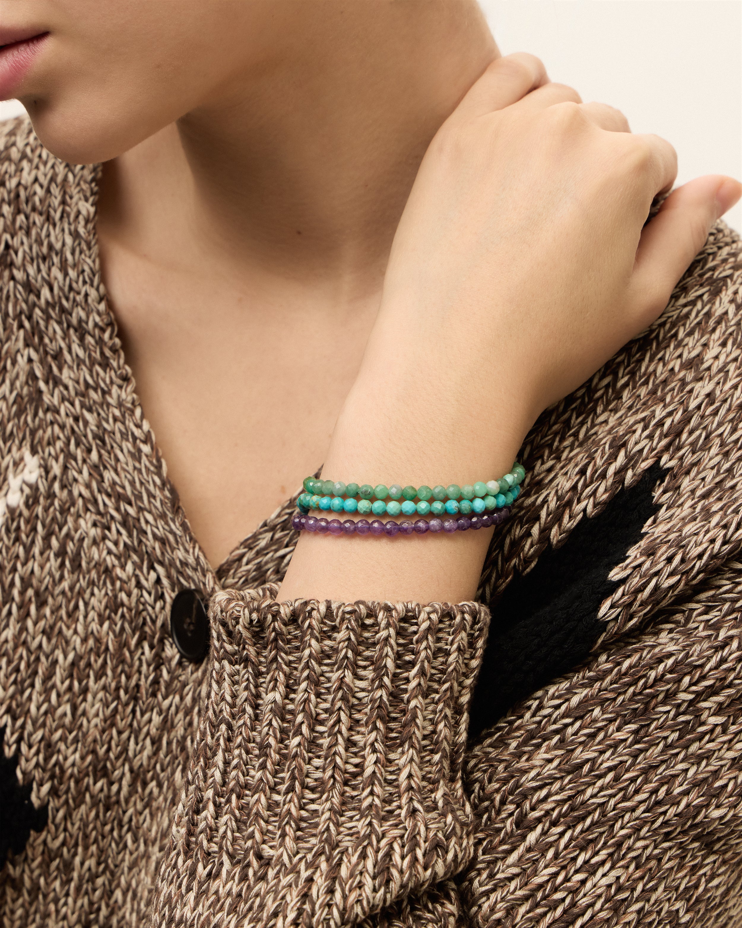 ETERNA VIRID Emerald / ETERNA AZURA Turquoise / ETERNA VÉLA Amethyst bracelet with polished gold spiral bead, 4 cm extension chain and clasp, arrowhead-shaped fantasy signature, and 4 mm faceted emerald, turquoise, amethyst bead strand.