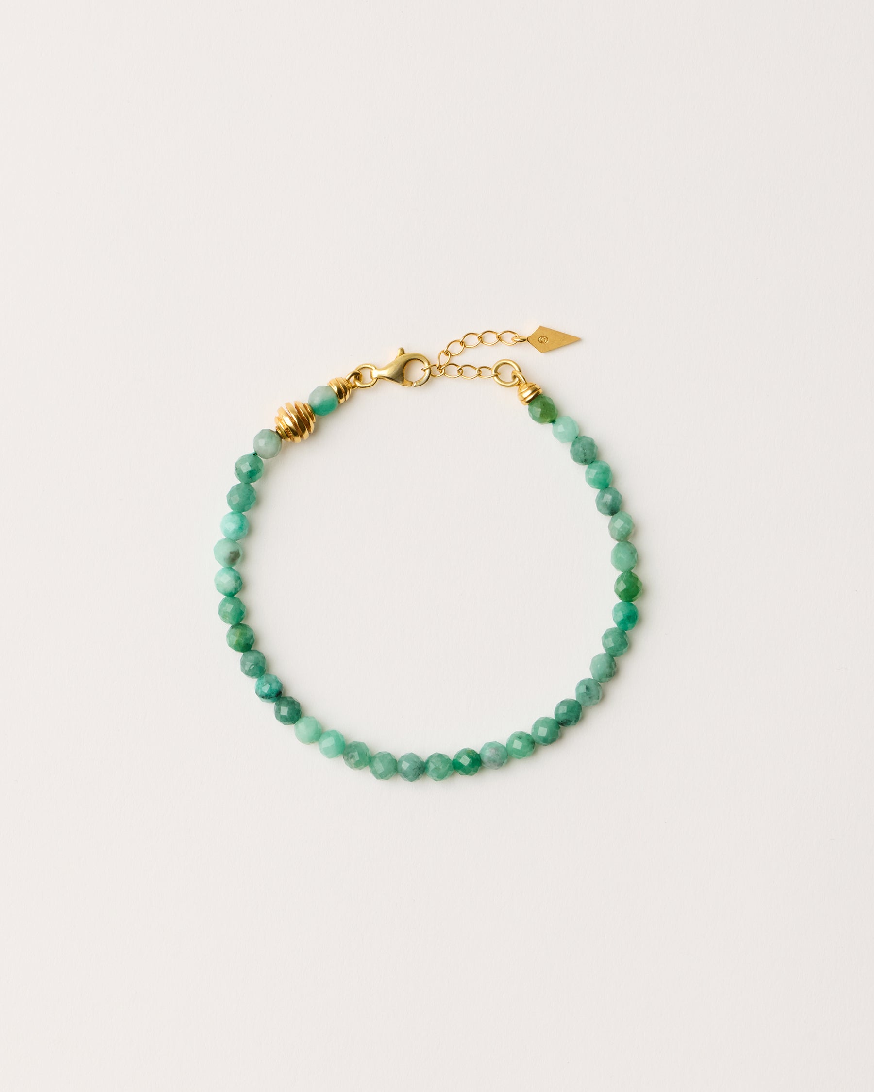 ETERNA VIRID Emerald bracelet with polished gold-plated silver spiral bead, 4 cm extension chain and clasp, arrowhead-shaped fantasy signature, and 4 mm faceted emerald bead strand.