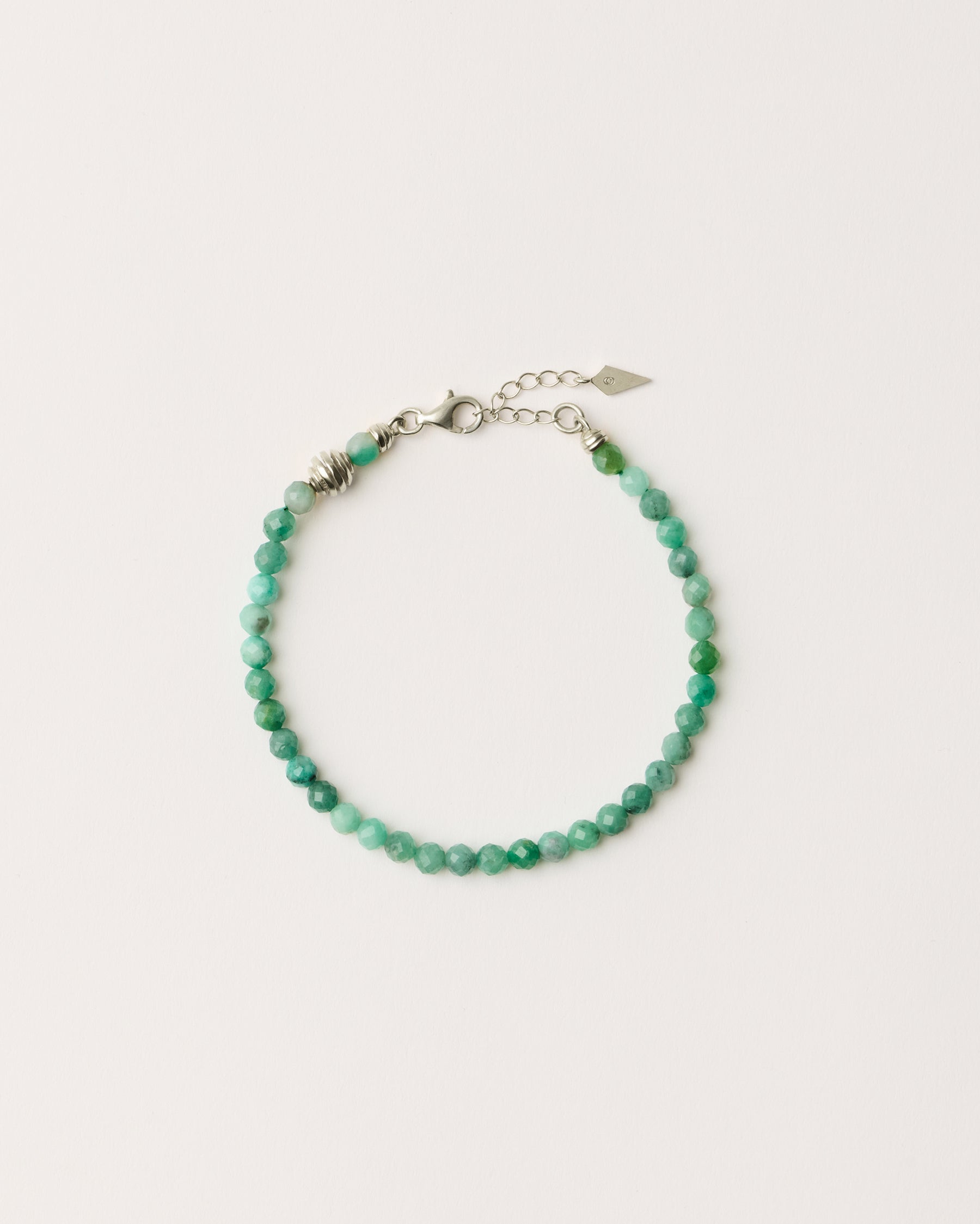 ETERNA VIRID Emerald bracelet with polished silver spiral bead, 4 cm extension chain and clasp, arrowhead-shaped fantasy signature, and 4 mm faceted emerald bead strand.
