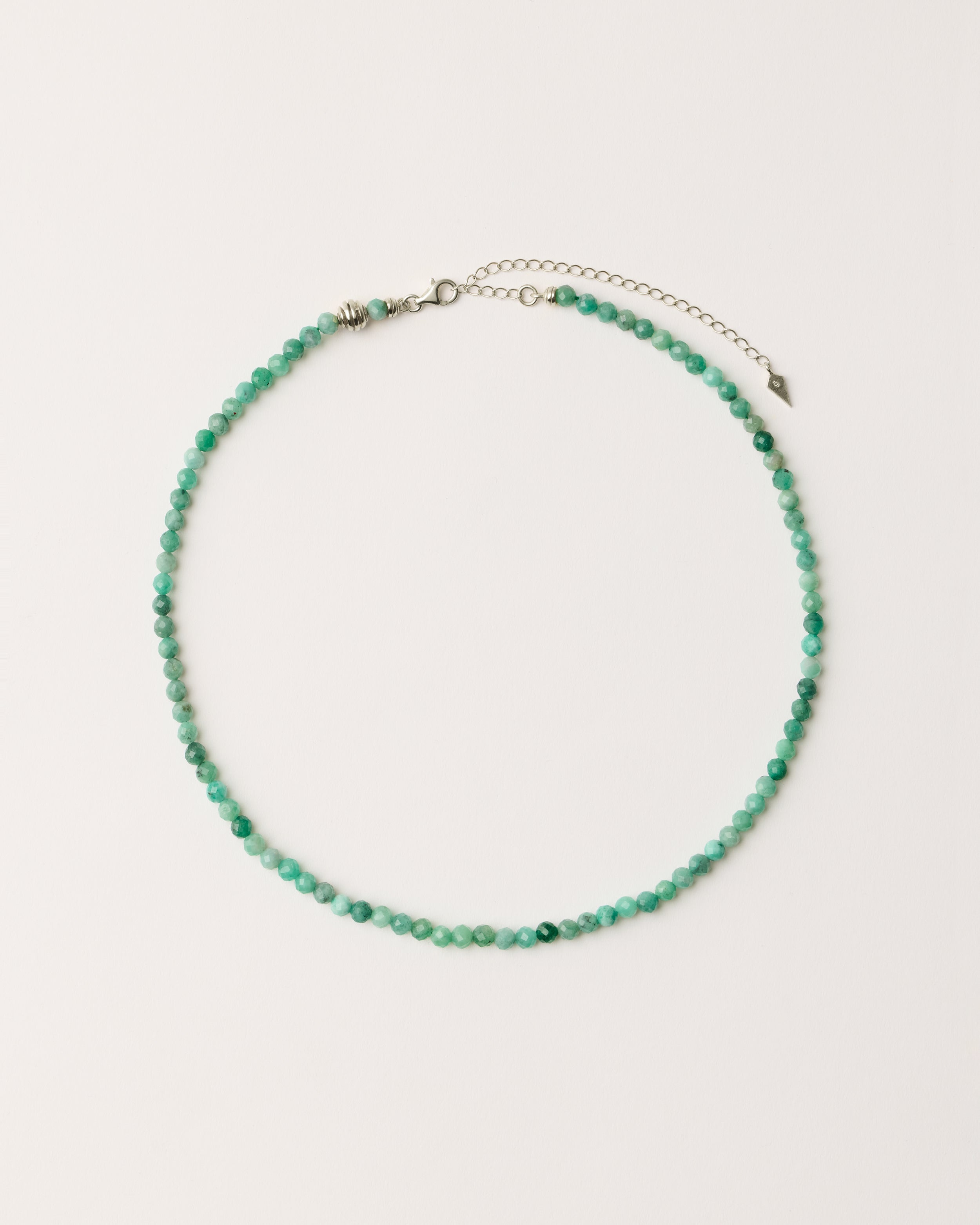 ETERNA VIRID Emerald necklace with polished silver spiral bead, 8 cm extension chain and clasp, arrowhead-shaped fantasy signature, and 4 mm faceted emerald bead strand.
