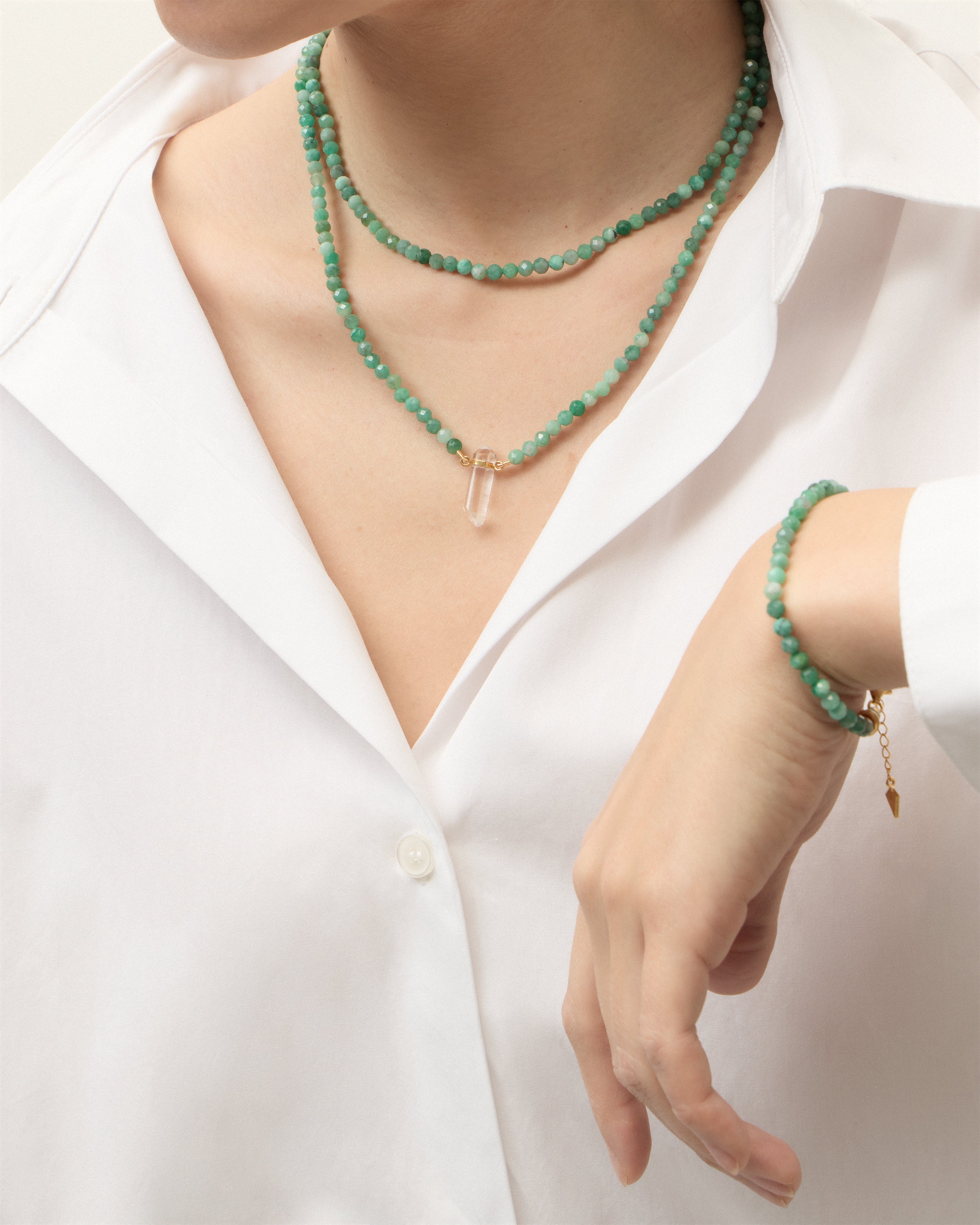 ENCARA / ETERNA VIRID Emerald necklaces and bracelet with polished gold-plated silver spiral bead, extension chain and clasp, arrowhead-shaped fantasy signature, and 4 mm faceted emerald bead strand and raw polished quartz point pendant.
