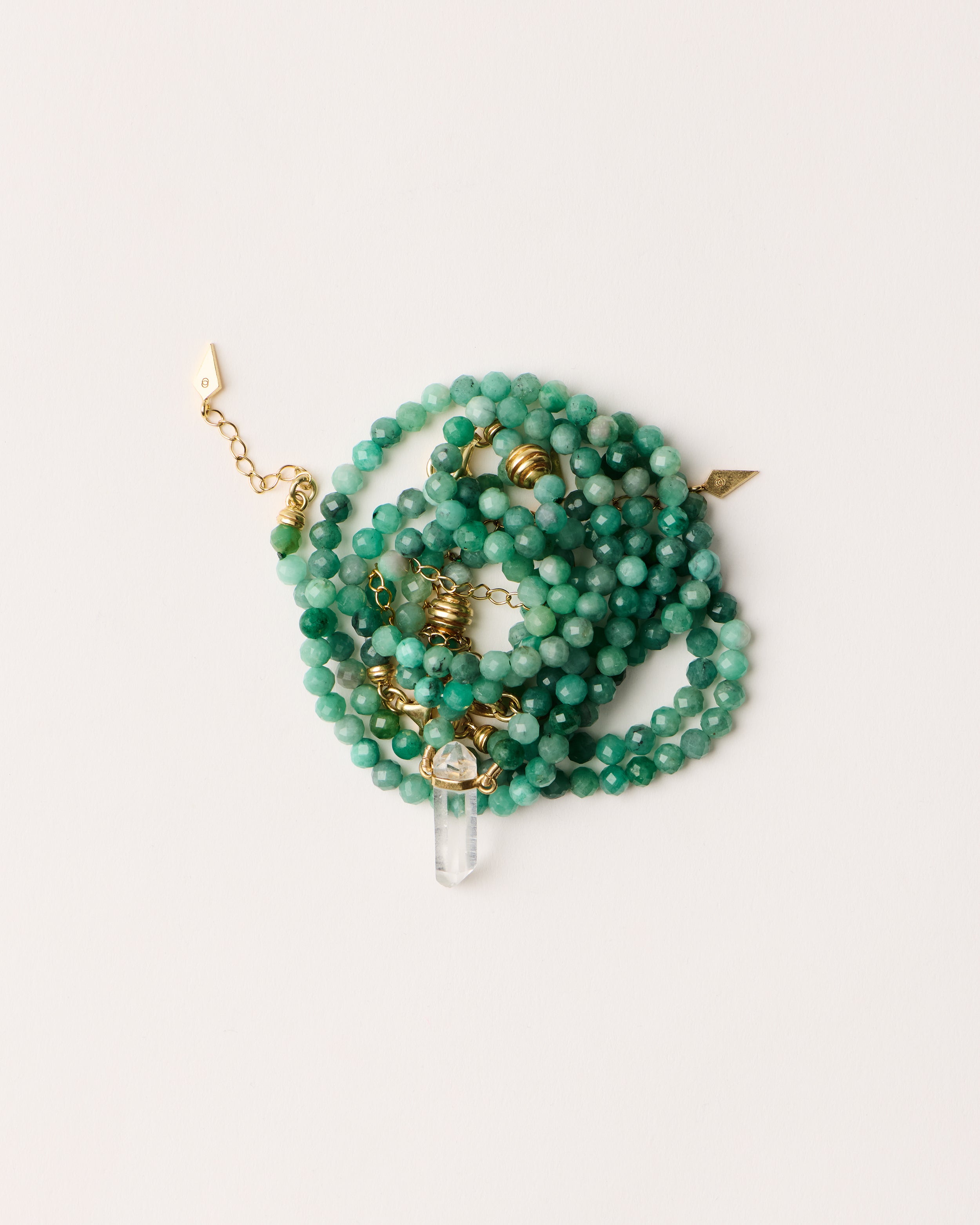 ENCARA / ETERNA VIRID Emerald necklaces and bracelet with polished gold spiral bead, extension chain and clasp, arrowhead-shaped fantasy signature, and 4 mm faceted emerald bead strand and raw polished quartz point pendant.