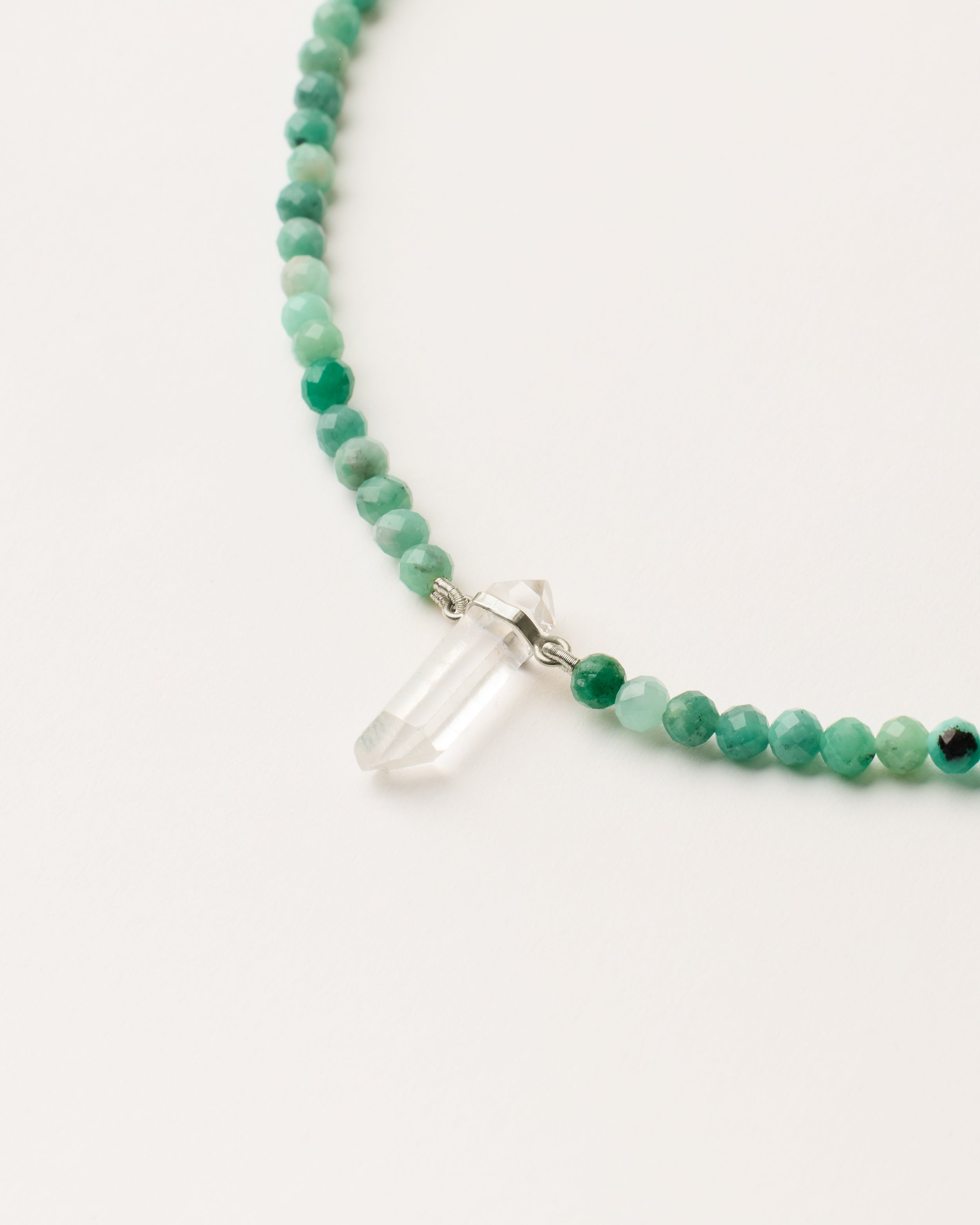 ENCARA VIRID Emerald necklace with raw polished quartz point pendant, silver 8 cm extension chain and clasp, arrowhead-shaped fantasy signature, and 4 mm faceted emerald bead strand.