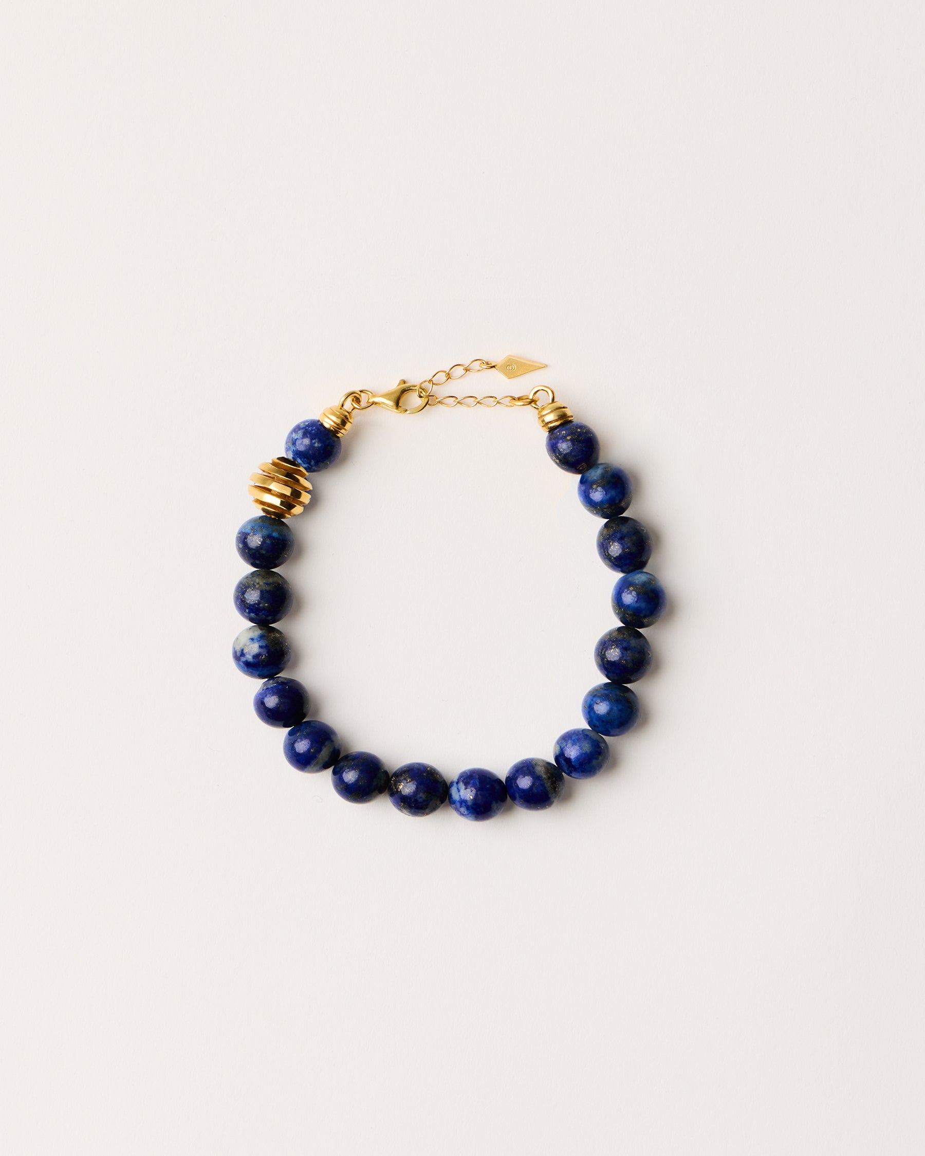ETERNA NOCTA Lapis Lazuli necklace with polished gold-plated silver spiral bead, 8 cm extension chain and clasp, arrowhead-shaped fantasy signature, and 8 mm faceted lazurite bead strand.