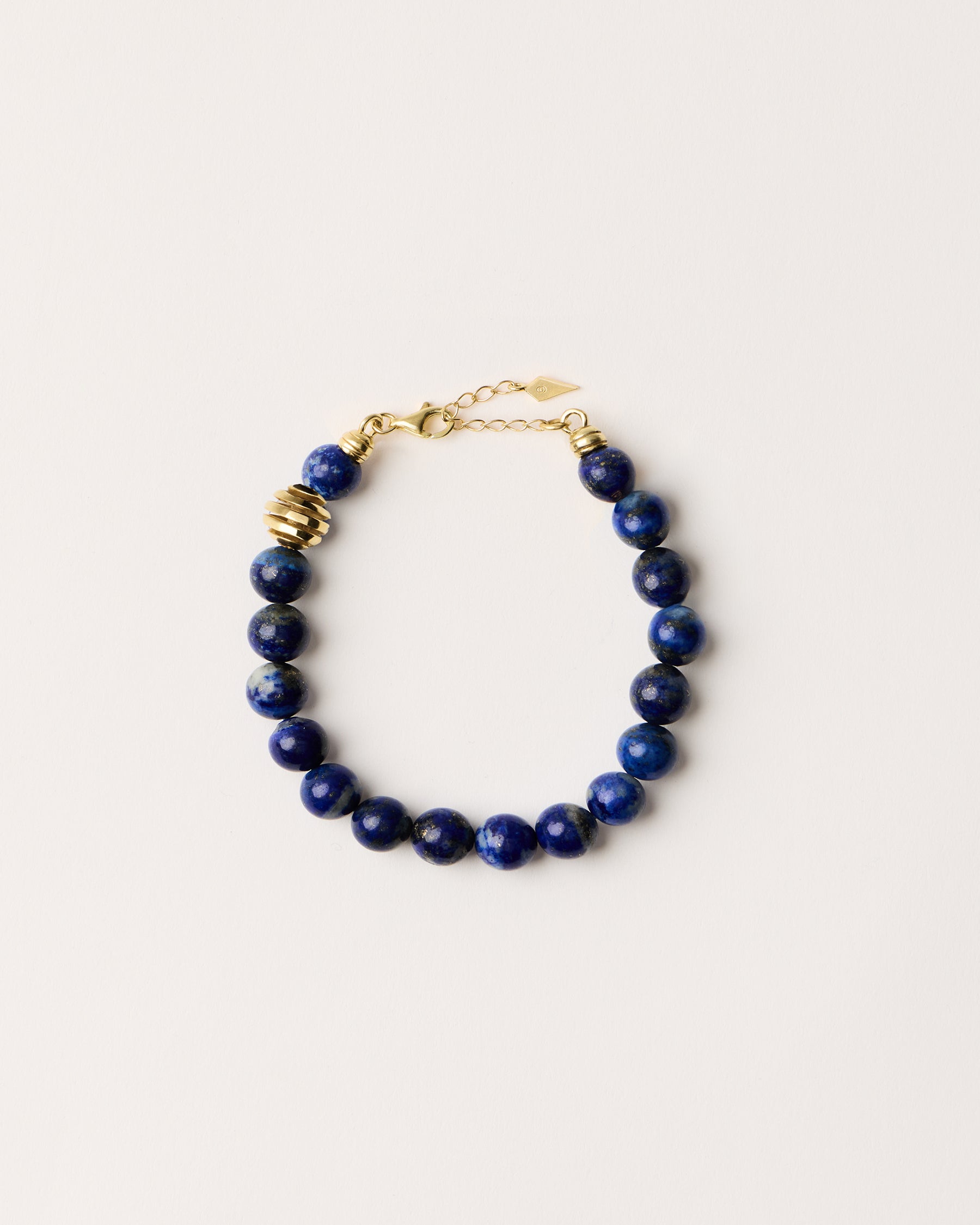 ETERNA NOCTA Lapis Lazuli necklace with polished gold spiral bead, 8 cm extension chain and clasp, arrowhead-shaped fantasy signature, and 8 mm faceted lazurite bead strand.