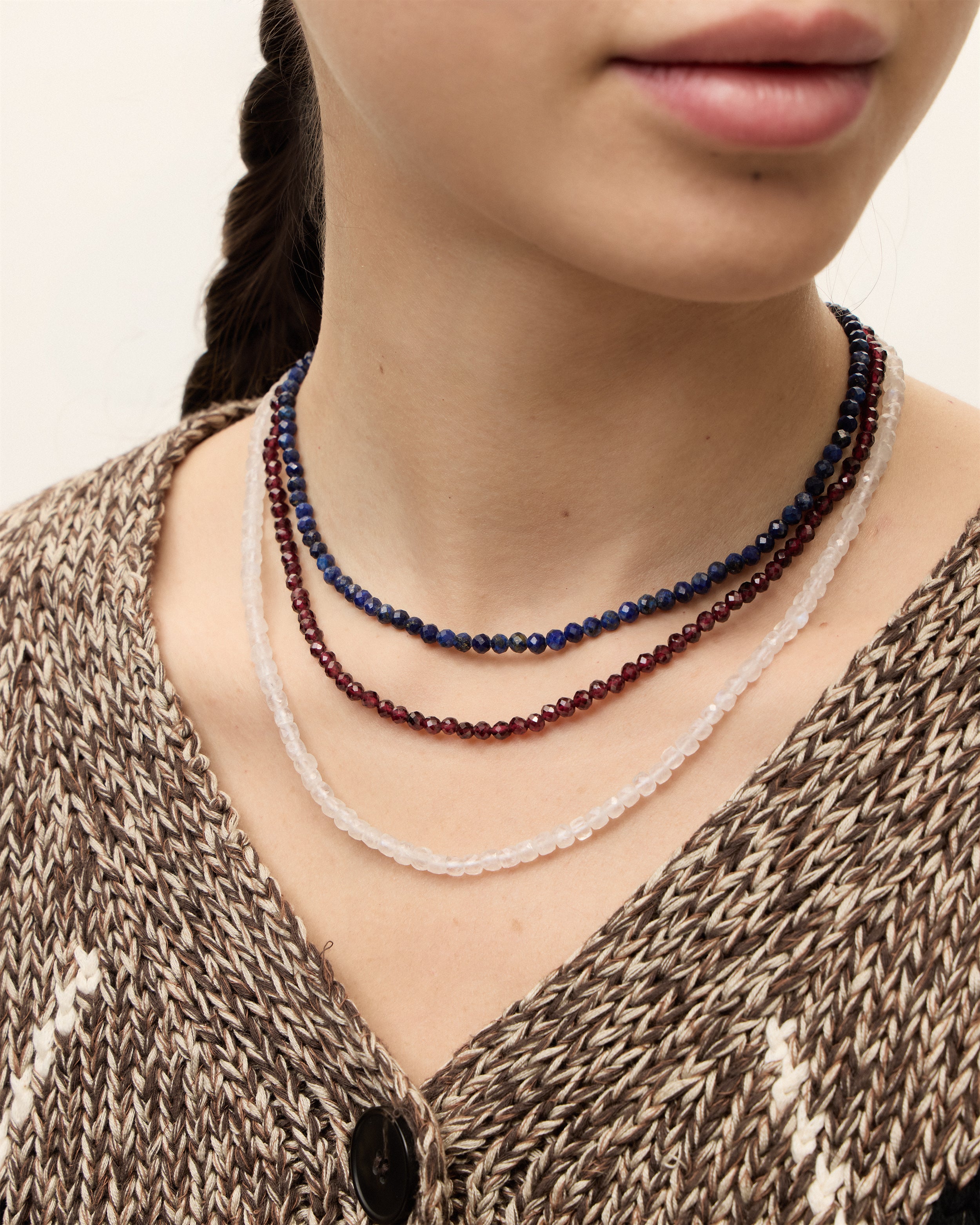 ETERNA NOCTA Lapis Lazuli / ETERNA LUNOR Moonstone / ETERNA INFERA Garnet necklace with polished gold spiral bead, 8 cm extension chain and clasp, arrowhead-shaped fantasy signature, and 4 mm faceted lazurite, moonstone, garnet, bead strand.