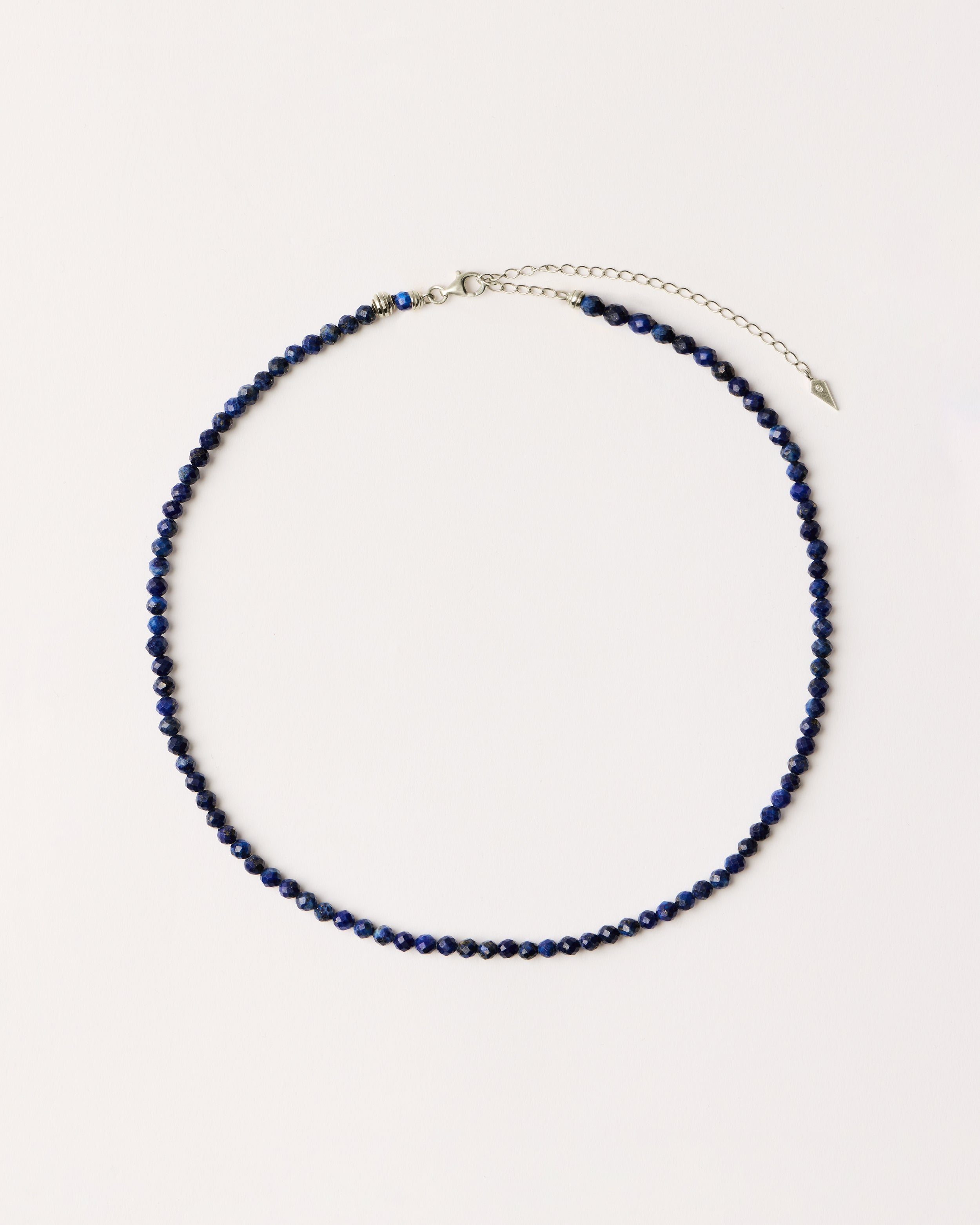 ETERNA NOCTA Lapis Lazuli necklace with polished silver spiral bead, 8 cm extension chain and clasp, arrowhead-shaped fantasy signature, and 4 mm faceted lazurite bead strand.
