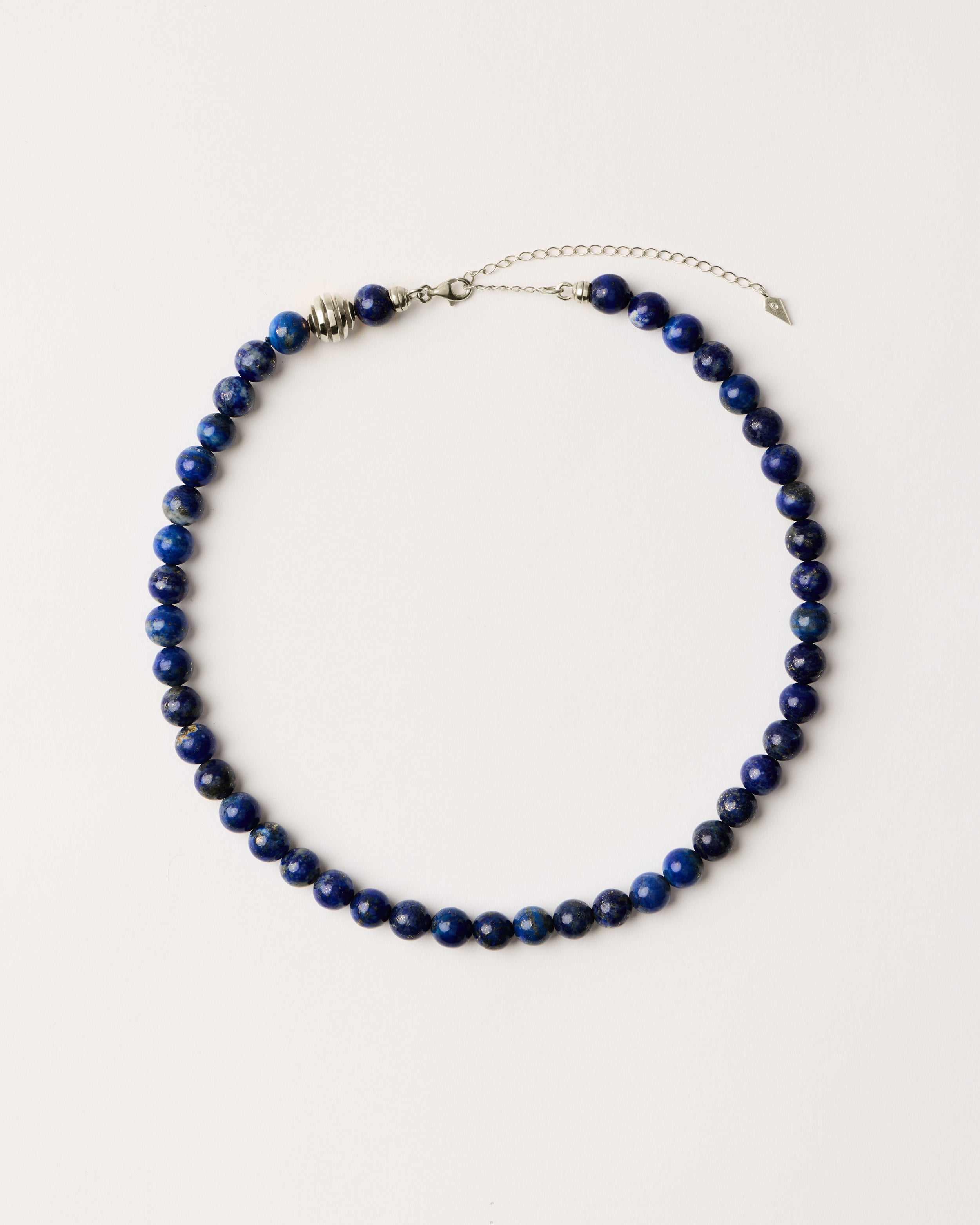 ETERNA NOCTA Lapis Lazuli necklace with polished silver spiral bead, 8 cm extension chain and clasp, arrowhead-shaped fantasy signature, and 8 mm faceted lazurite bead strand.