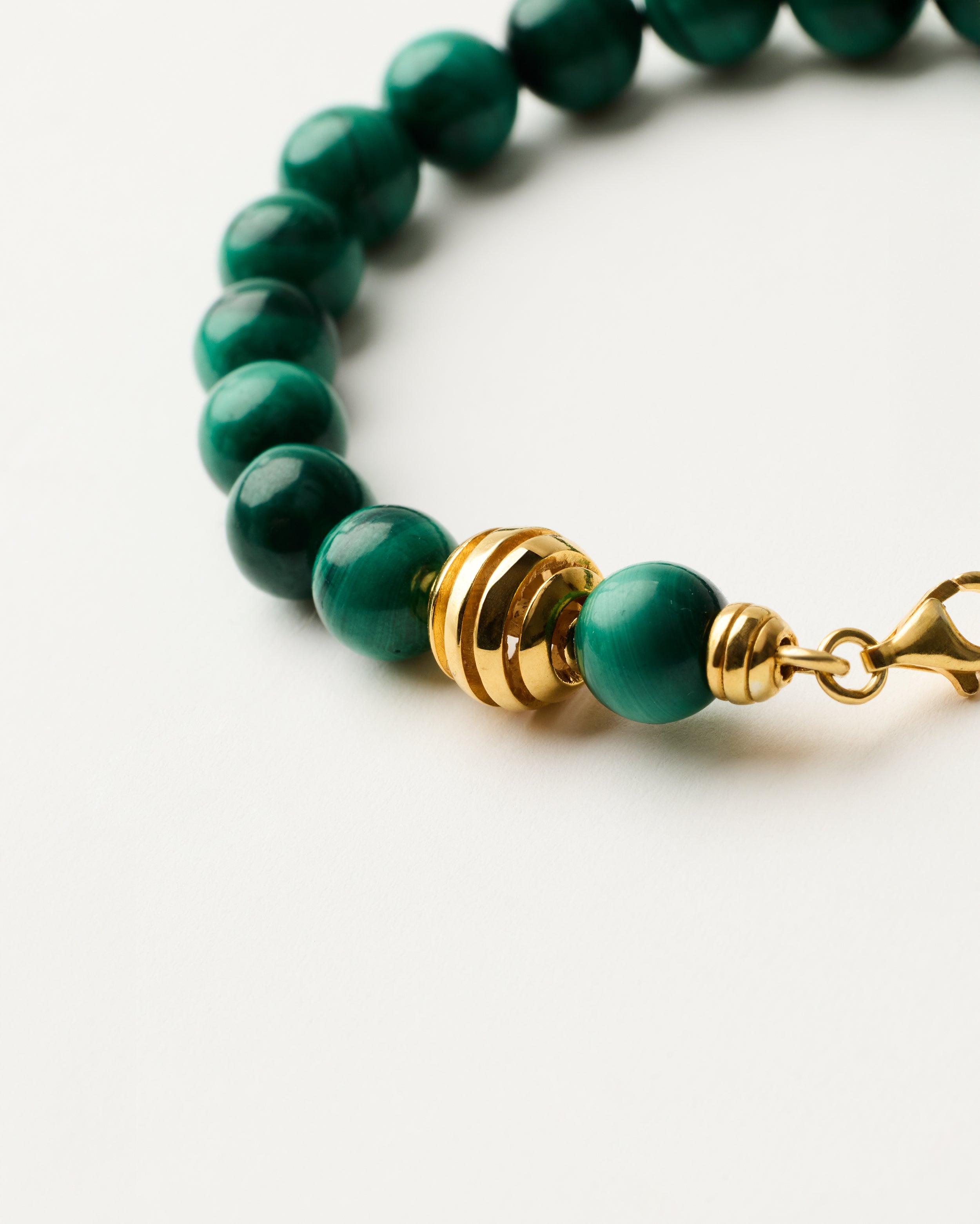 ETERNA VERDAN Malachite bracelet with polished gold-plated silver spiral bead, 4 cm extension chain and clasp, arrowhead-shaped fantasy signature, and 8 mm faceted malachite bead strand.