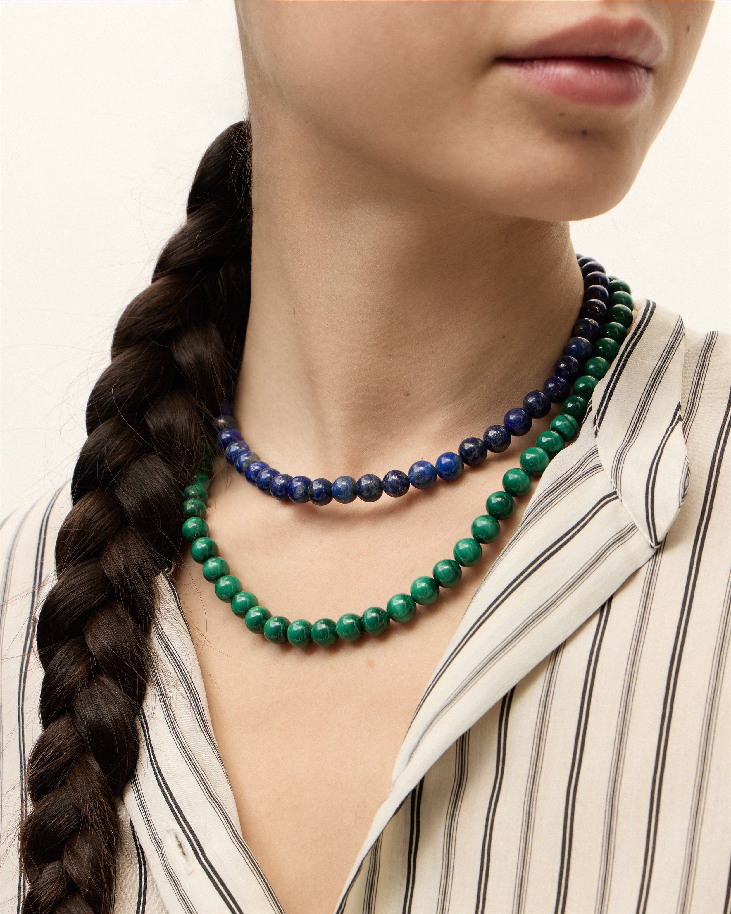 ENCARA NOCTA Lapis Lazuli / ENCARA VERDAN Malachite necklace with polished gold spiral bead, 8 cm extension chain and clasp, arrowhead-shaped fantasy signature, and 8 mm faceted lazurite / malachite bead strand.