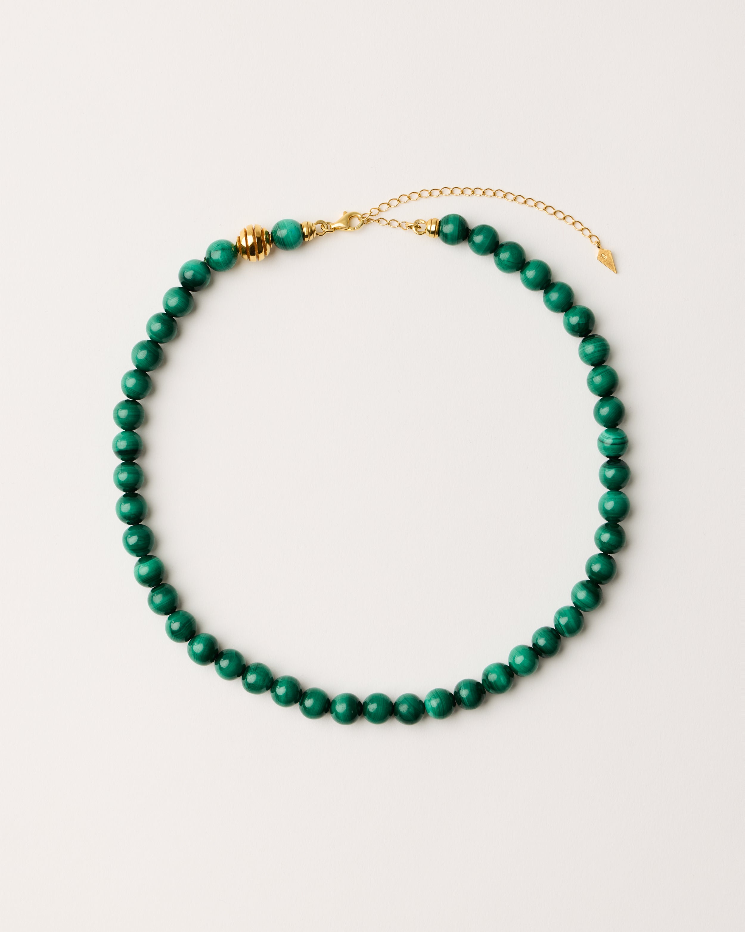 ETERNA VERDAN Malachite necklace with polished gold-plated silver spiral bead, 8 cm extension chain and clasp, arrowhead-shaped fantasy signature, and 8 mm faceted malachite bead strand.