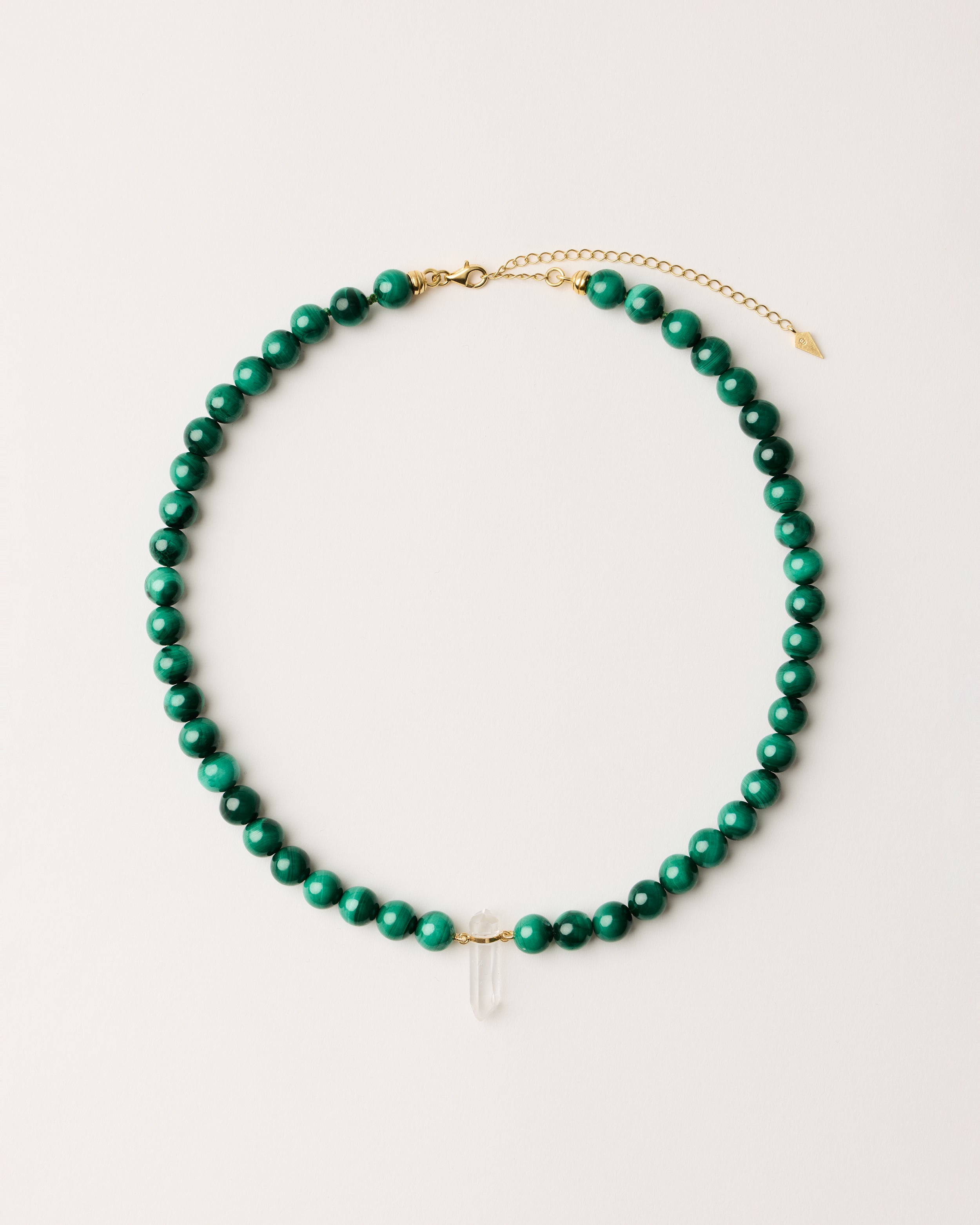 ENCARA VERDAN Malachite necklace with raw polished quartz point pendant, gold 8 cm extension chain and clasp, arrowhead-shaped fantasy signature, and 8 mm faceted malachite bead strand.