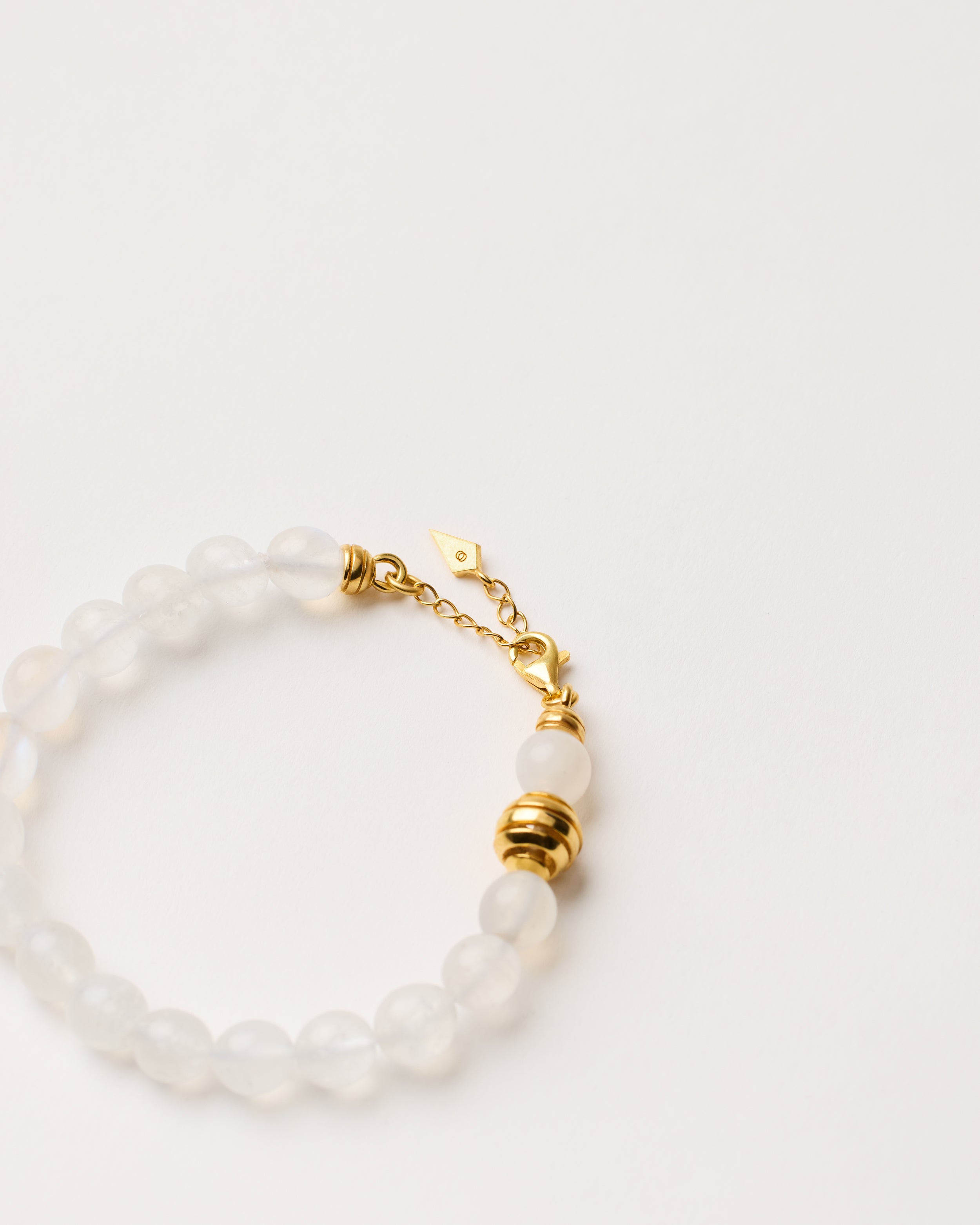 ETERNA LUNOR Moonstone bracelet with polished gold-plated silver spiral bead, 4 cm extension chain and clasp, arrowhead-shaped fantasy signature, and 8 mm faceted moonstone bead strand.