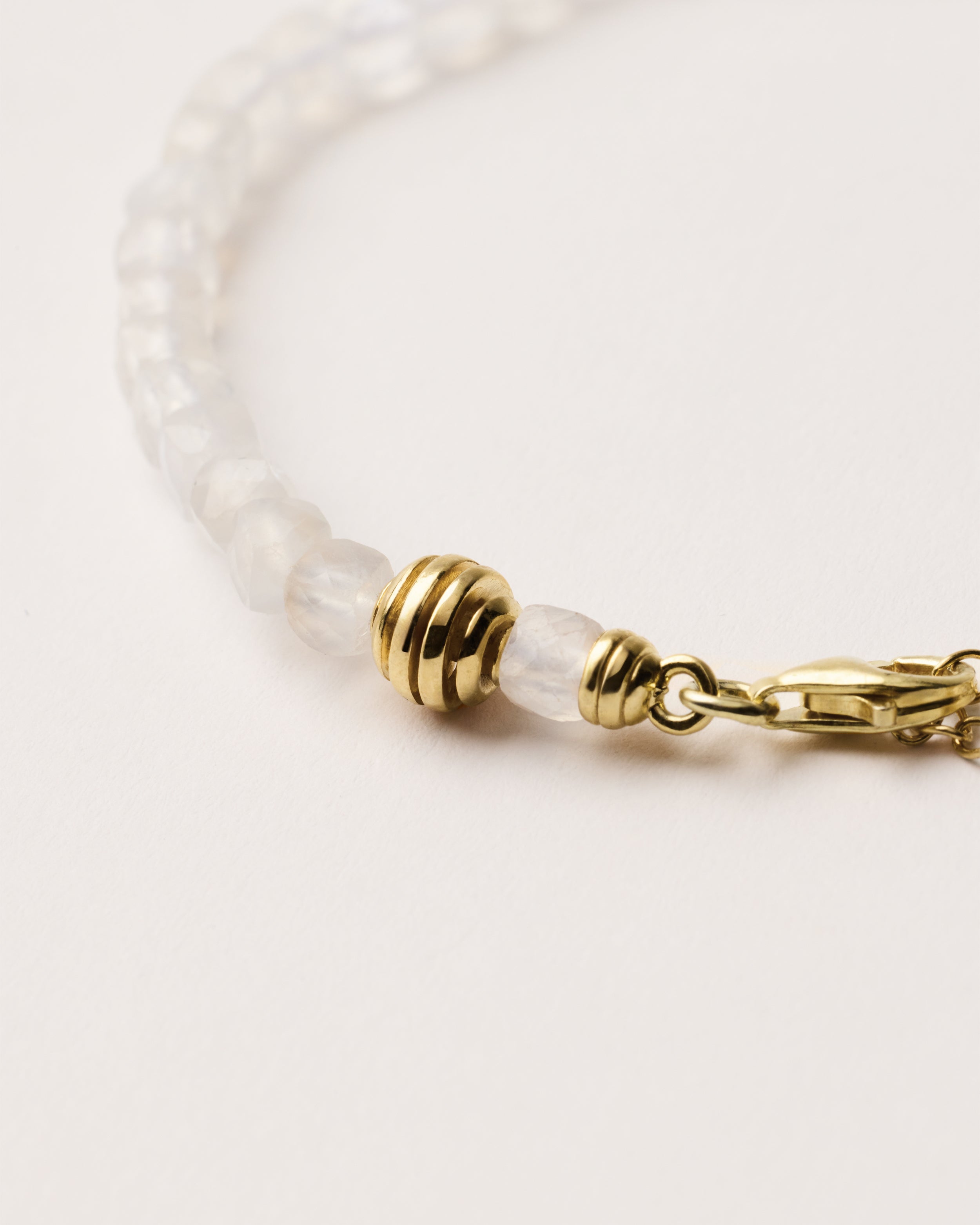 ETERNA LUNOR Moonstone bracelet with polished gold spiral bead, 4 cm extension chain and clasp, arrowhead-shaped fantasy signature, and 4 mm faceted moonstone bead strand.