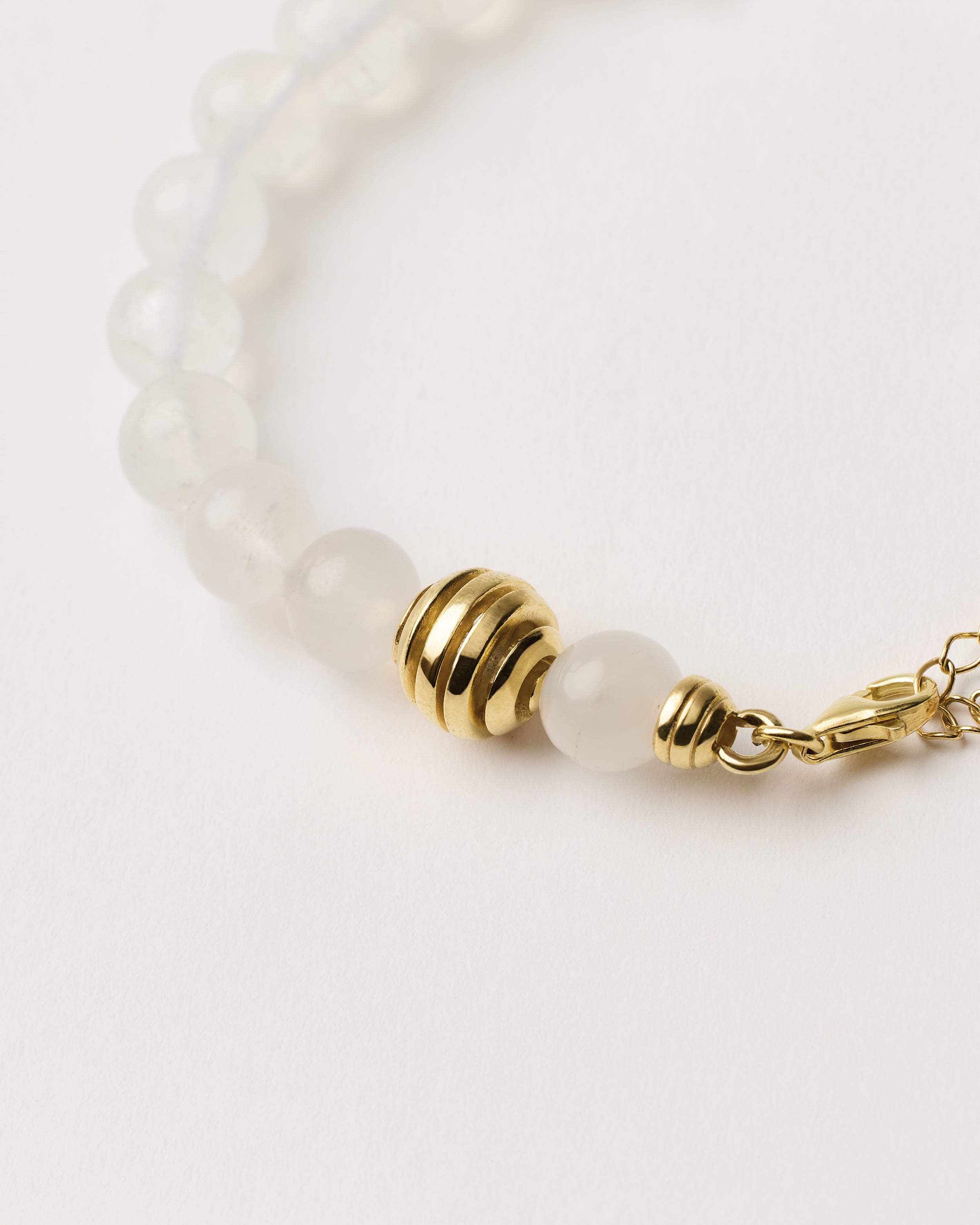 ETERNA LUNOR Moonstone bracelet with polished gold spiral bead, 4 cm extension chain and clasp, arrowhead-shaped fantasy signature, and 8 mm faceted moonstone bead strand.