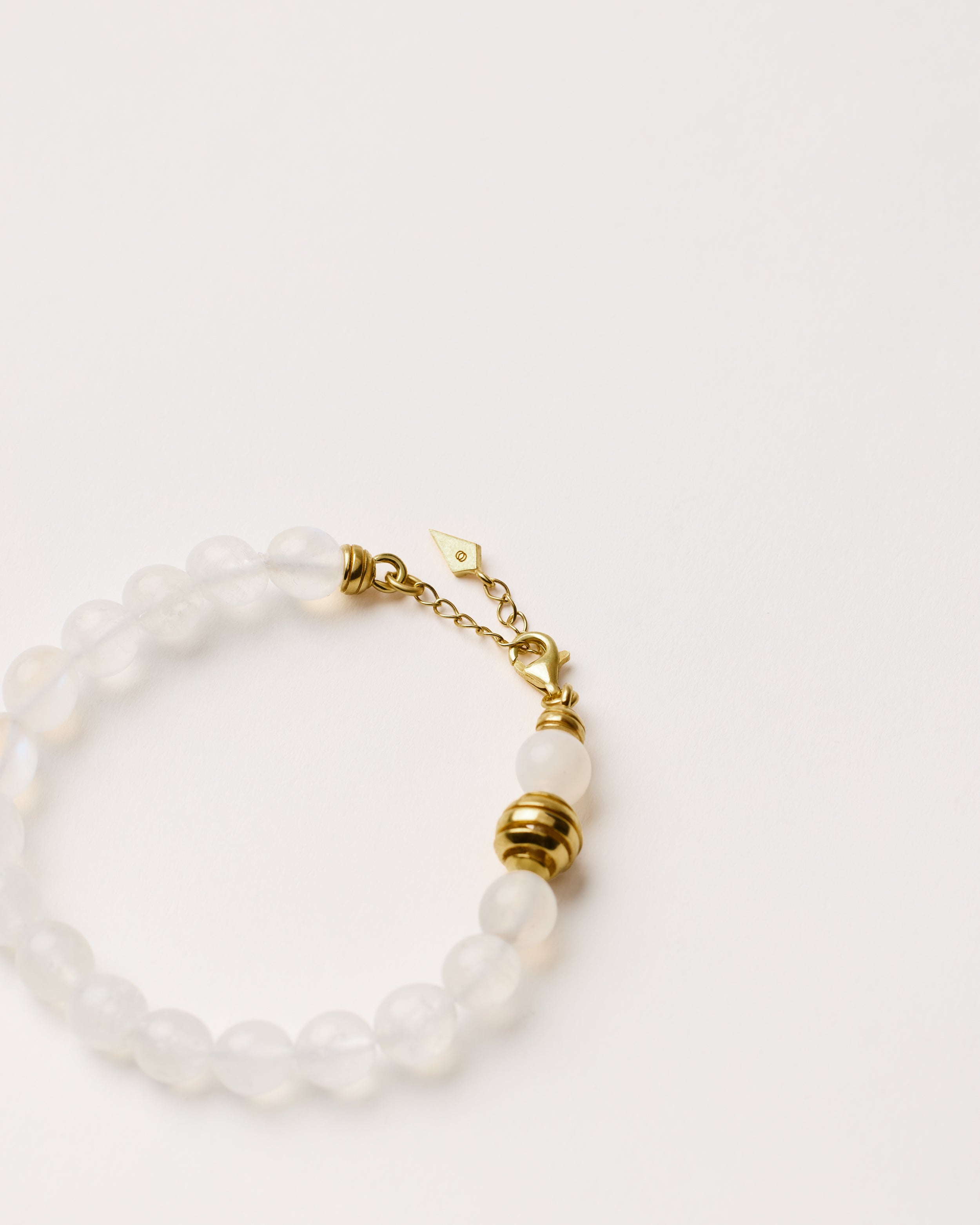 ETERNA LUNOR Moonstone bracelet with polished gold spiral bead, 4 cm extension chain and clasp, arrowhead-shaped fantasy signature, and 8 mm faceted moonstone bead strand.