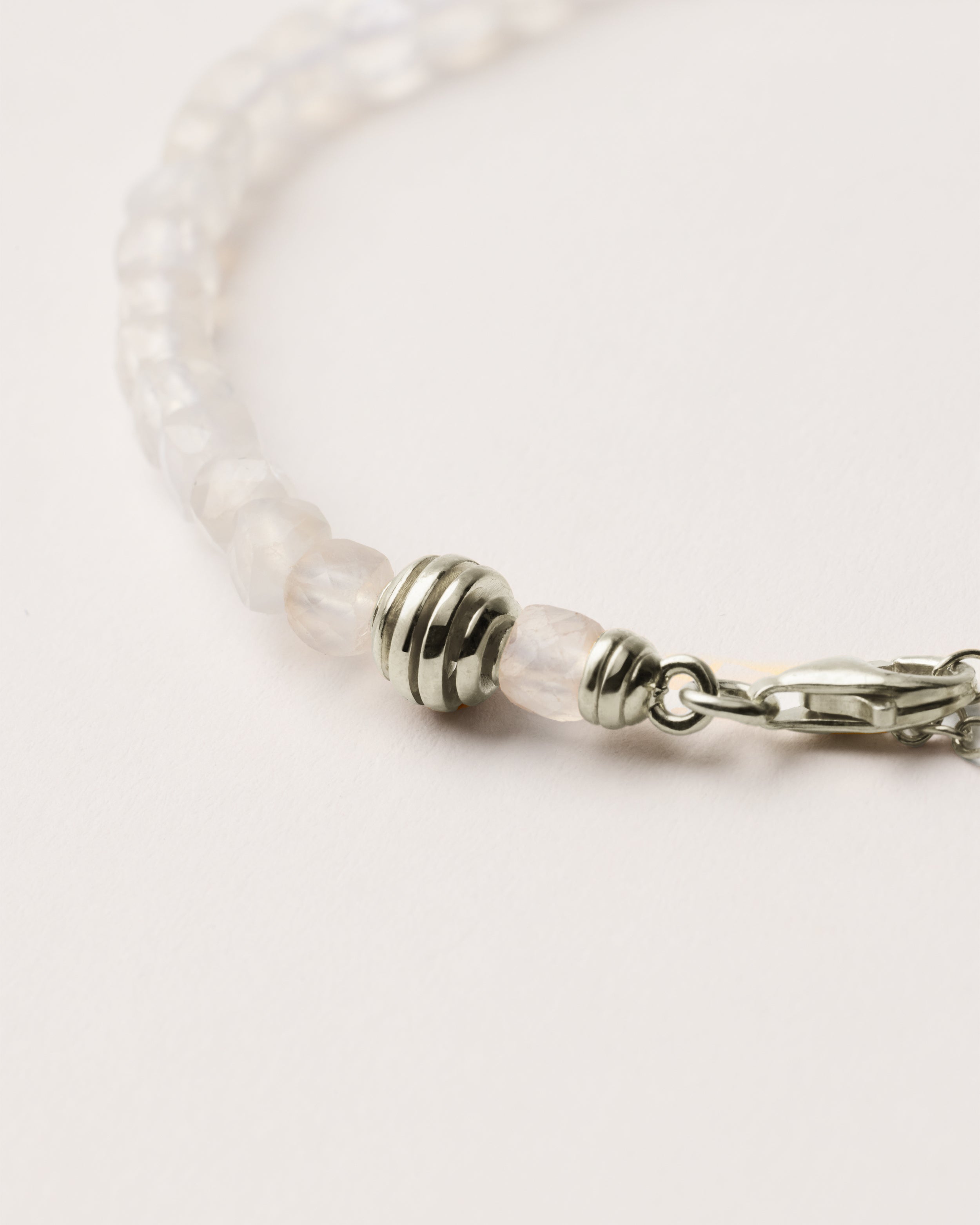 ETERNA LUNOR Moonstone bracelet with polished silver spiral bead, 4 cm extension chain and clasp, arrowhead-shaped fantasy signature, and 4 mm faceted moonstone bead strand.